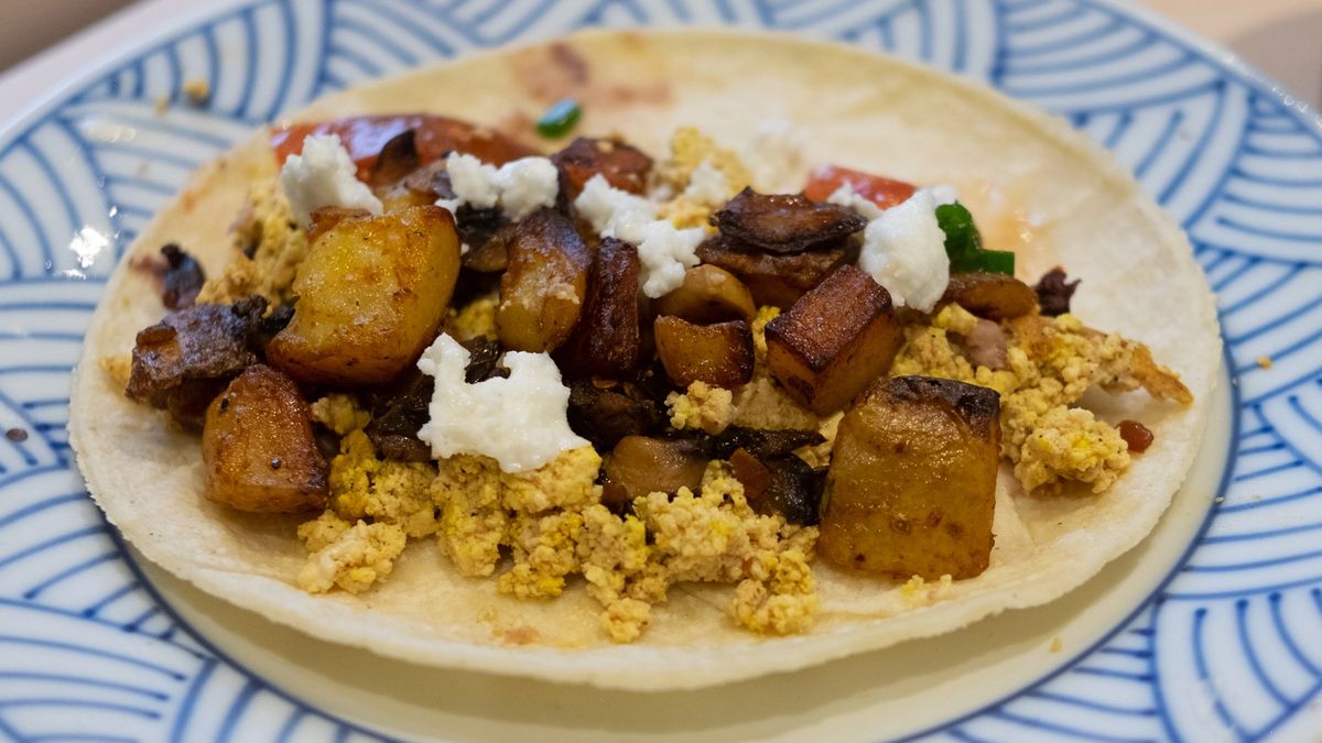 A breakfast taco with assorted ingredients 