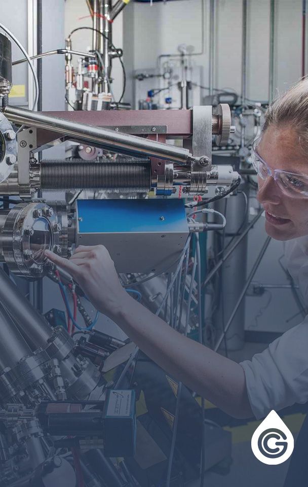 Female engineer wearing safety goggles examines steel equipment