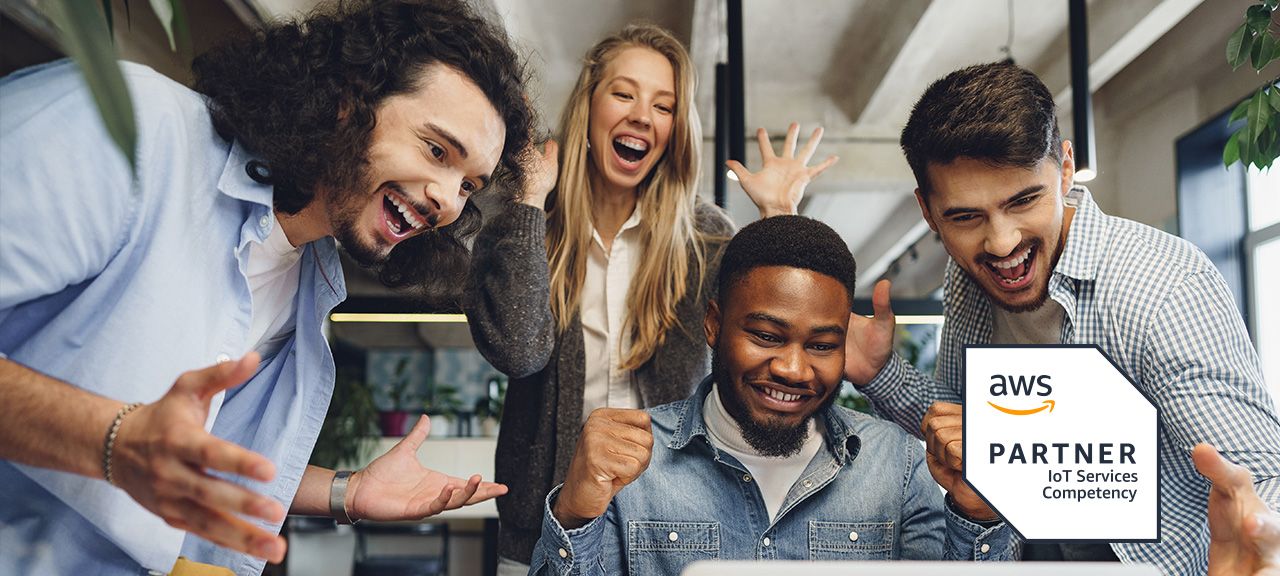 A group of office workers celebrate around a laptop