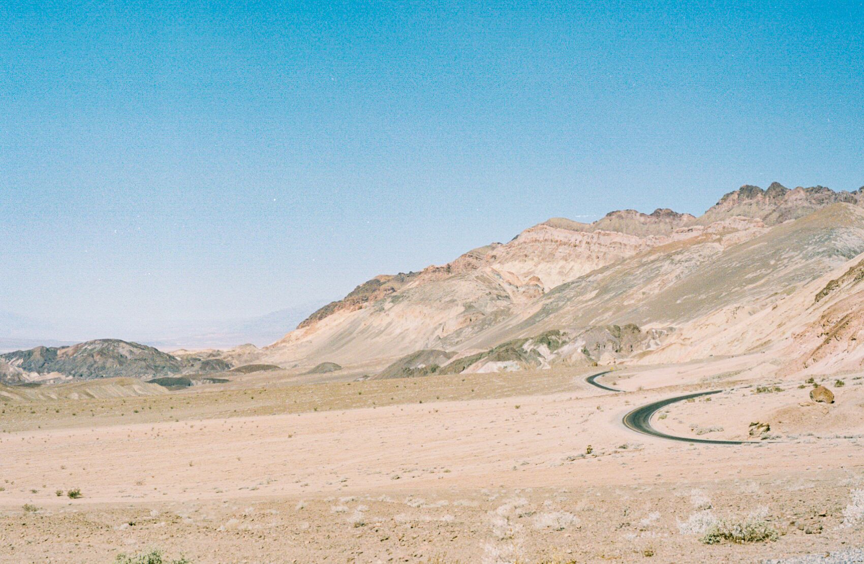 A winding road along the base of the mountains at the edge of Death Valley