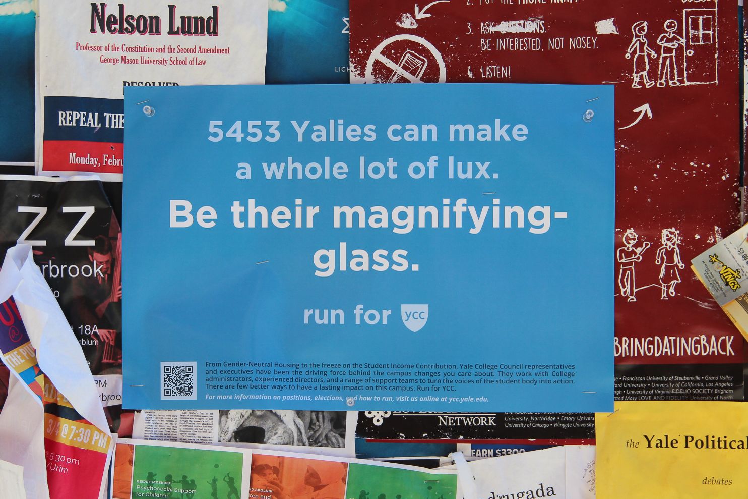 A blue poster on a bulletin board reads: 5453 Yalies can make a whole lot of lux. Be their magnifying-glass. Run for YCC.