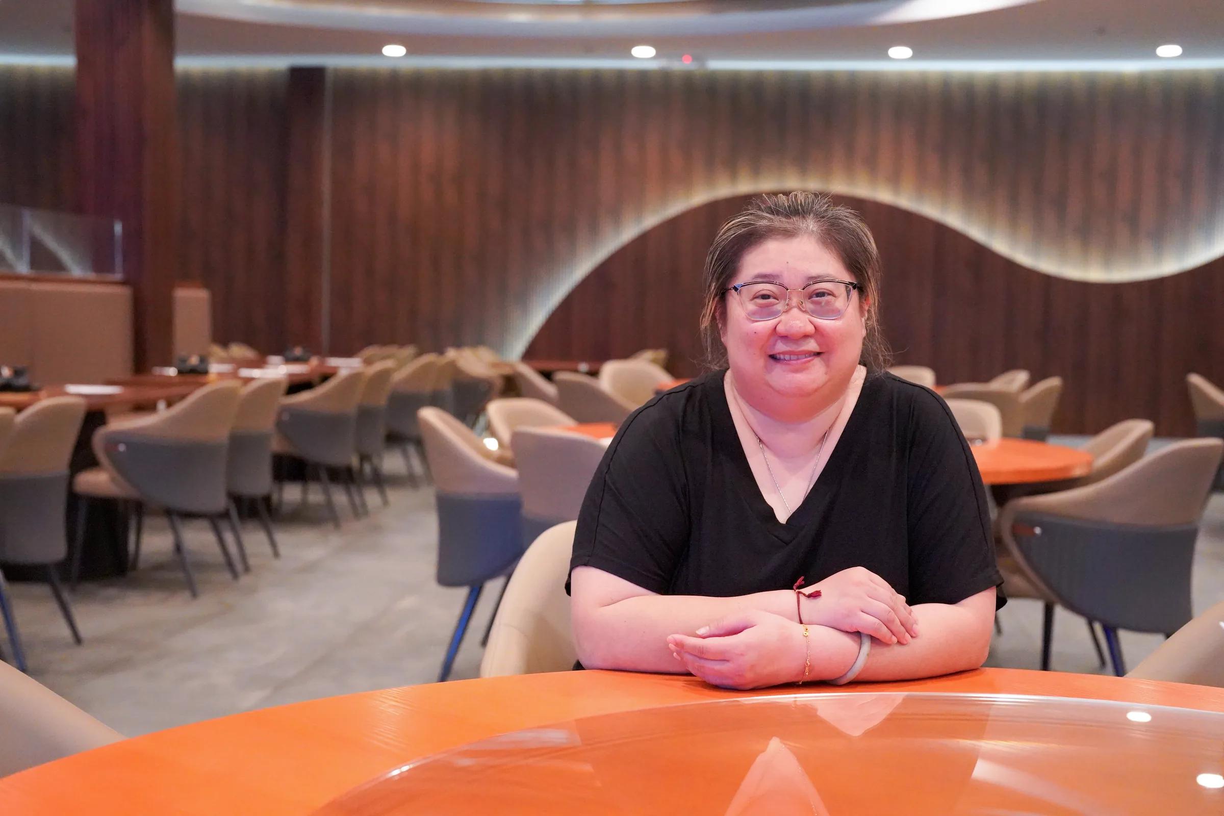 A restaurant owner photographed inside her dining room