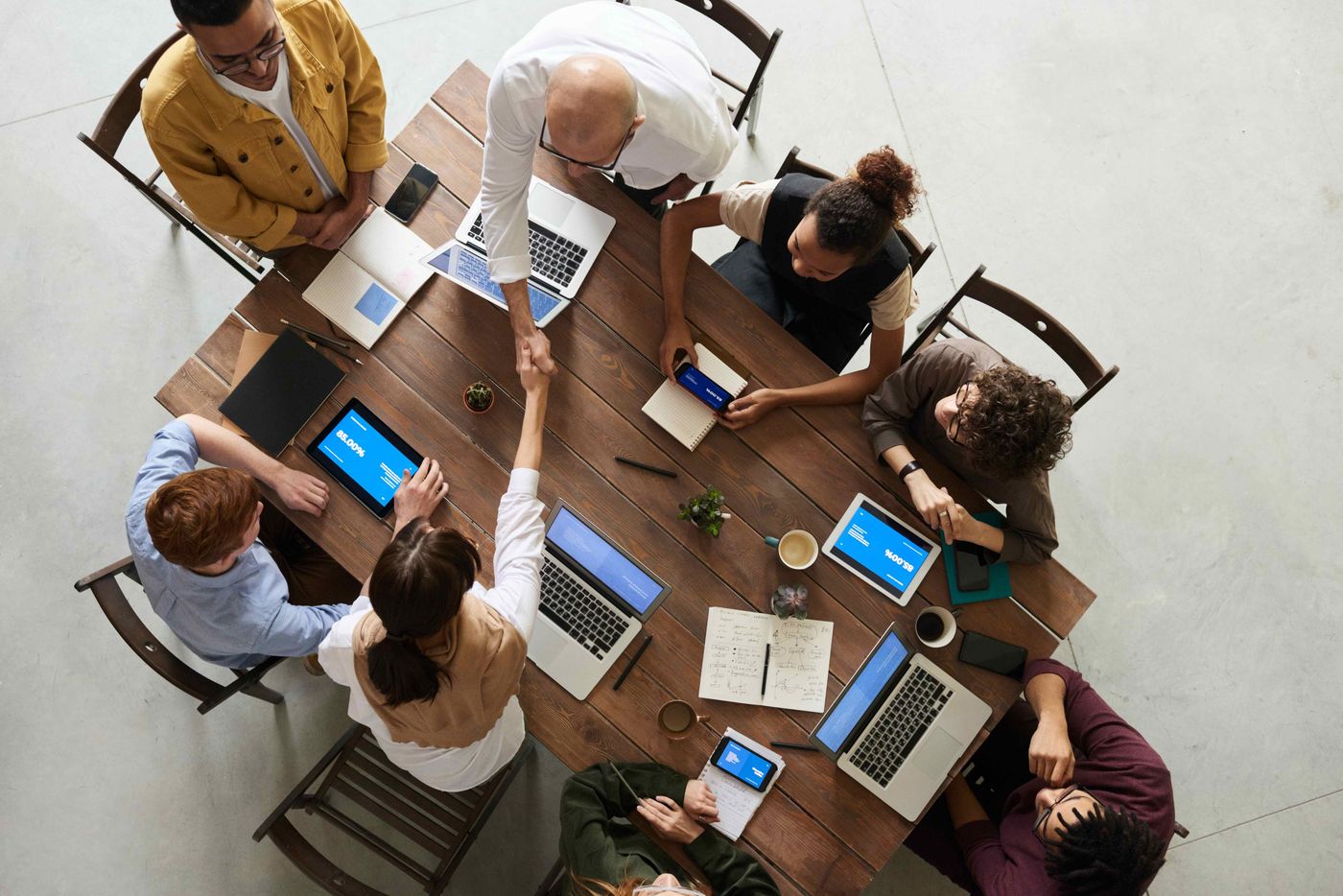 a table with eight startup founders closing hands after finishing their startup founders agreement