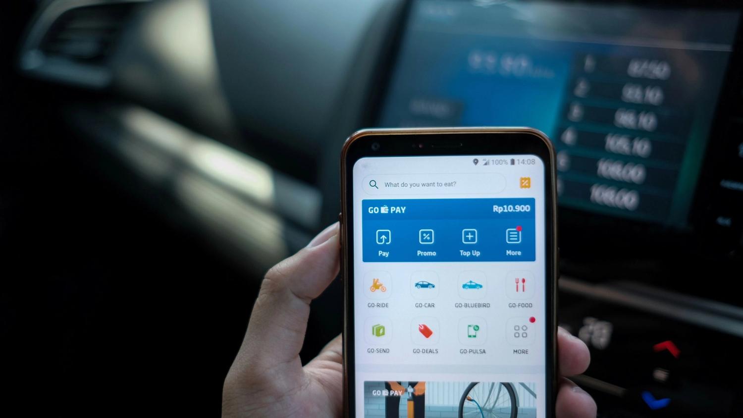 A man holding his phone that shows a fintech app
