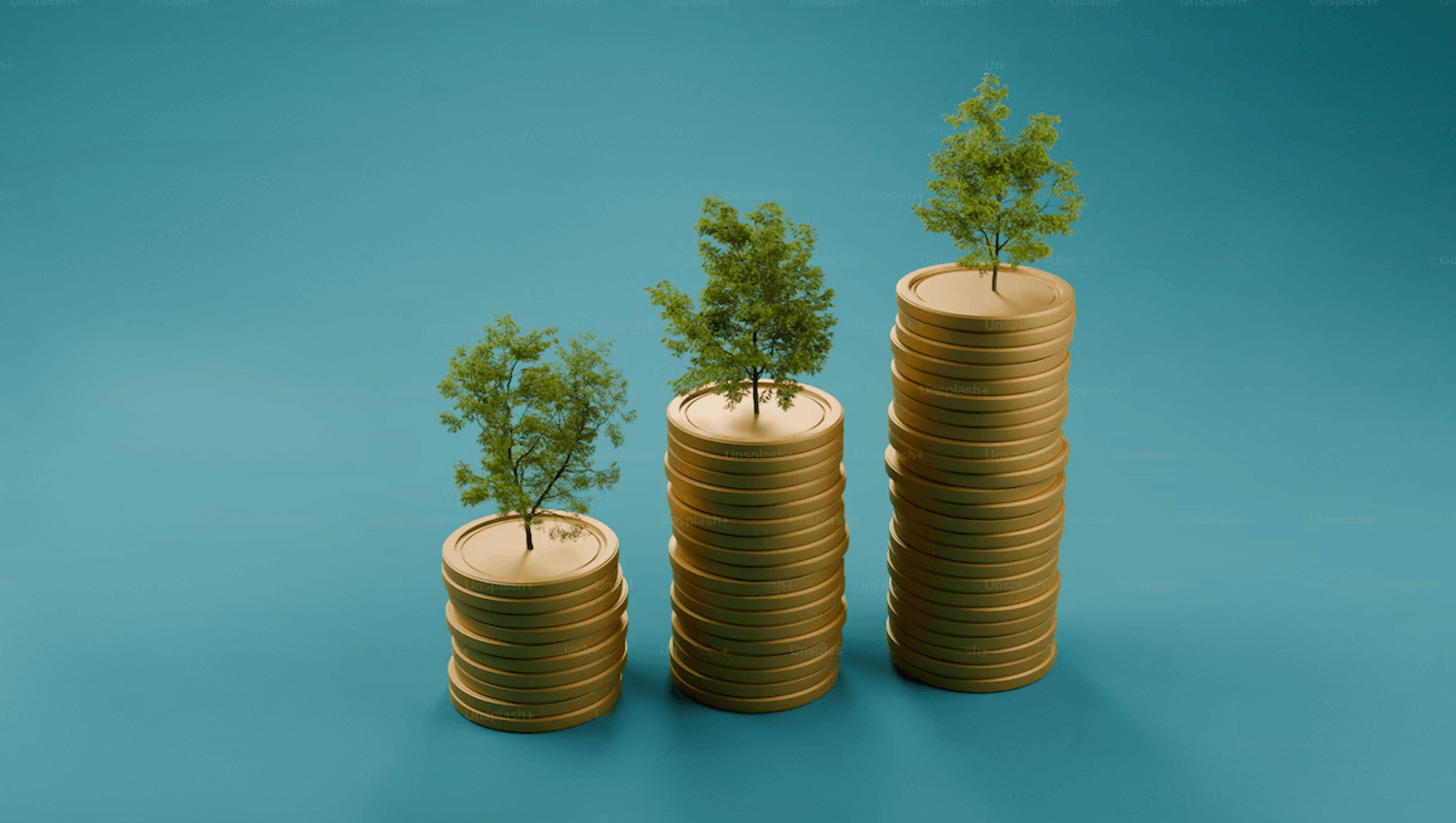 A stack of coins with small trees growing on top, symbolizing crowdfunding and growth for startups