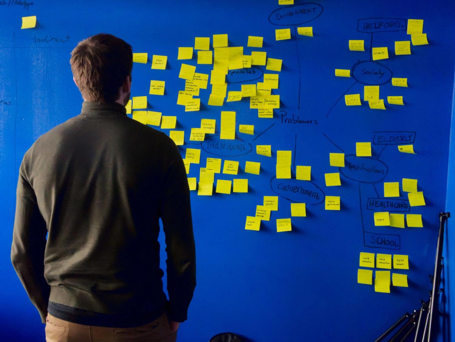 A man taking a look at a blue wall pondering why it is important to invest in early stage startups