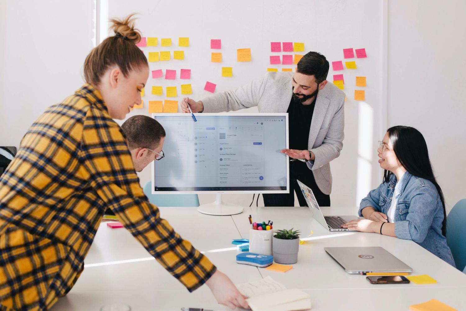 Team working on building their startup company culture and culture values in their office space with sticky notes on the wall