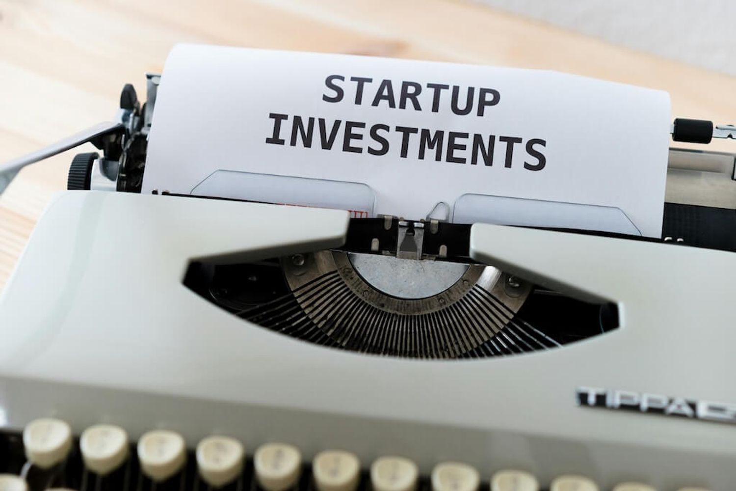 A vintage typewriter with a sheet of paper that reads "startup investment" in bold letters, meant for grants for small business startup