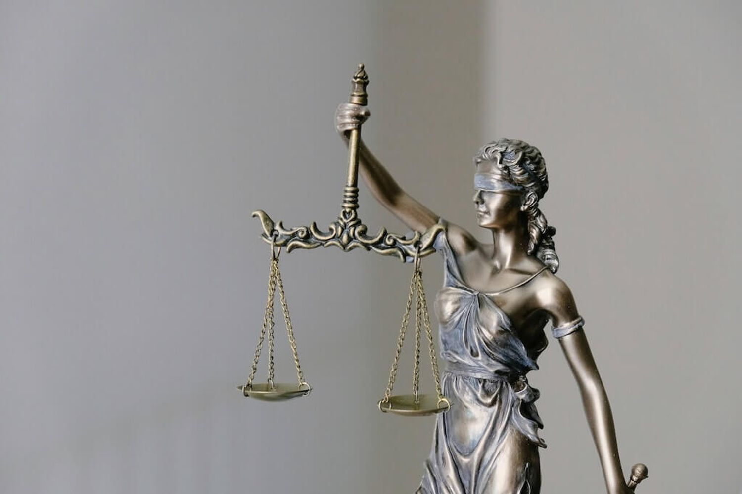 A statue of Lady Justice, holding scales indicating finding fairness within common startup contract clauses