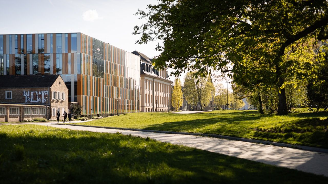 Modern university campus building with glass facade and green lawn, representing NUST admission