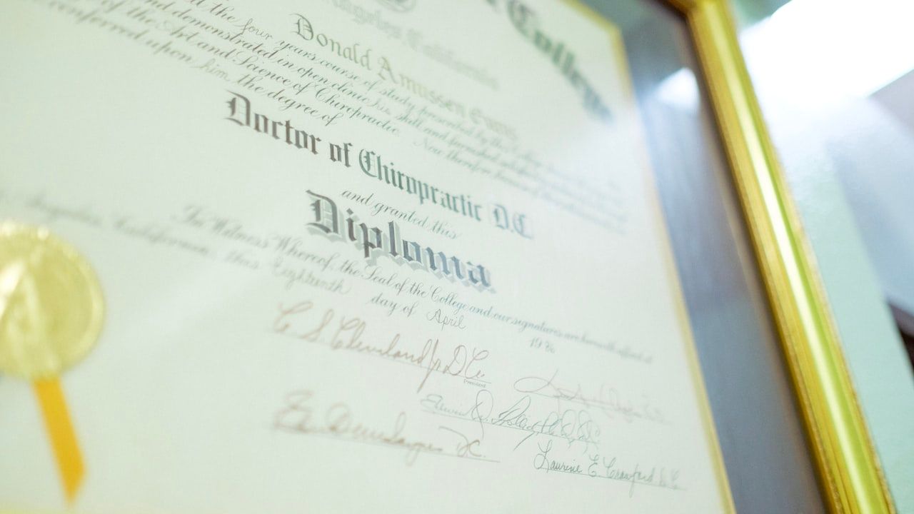 Close-up of a framed academic diploma certificate with gold seal, representing educational qualifications and equivalence