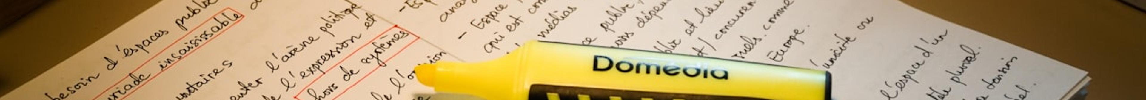 Yellow highlighter resting on handwritten study notes with key terms circled, representing prioritising important topics for exam preparation