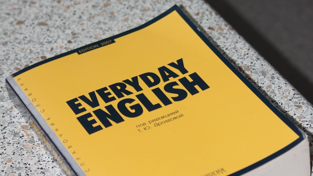 A yellow Everyday English textbook lying on a surface, representing English grammar study