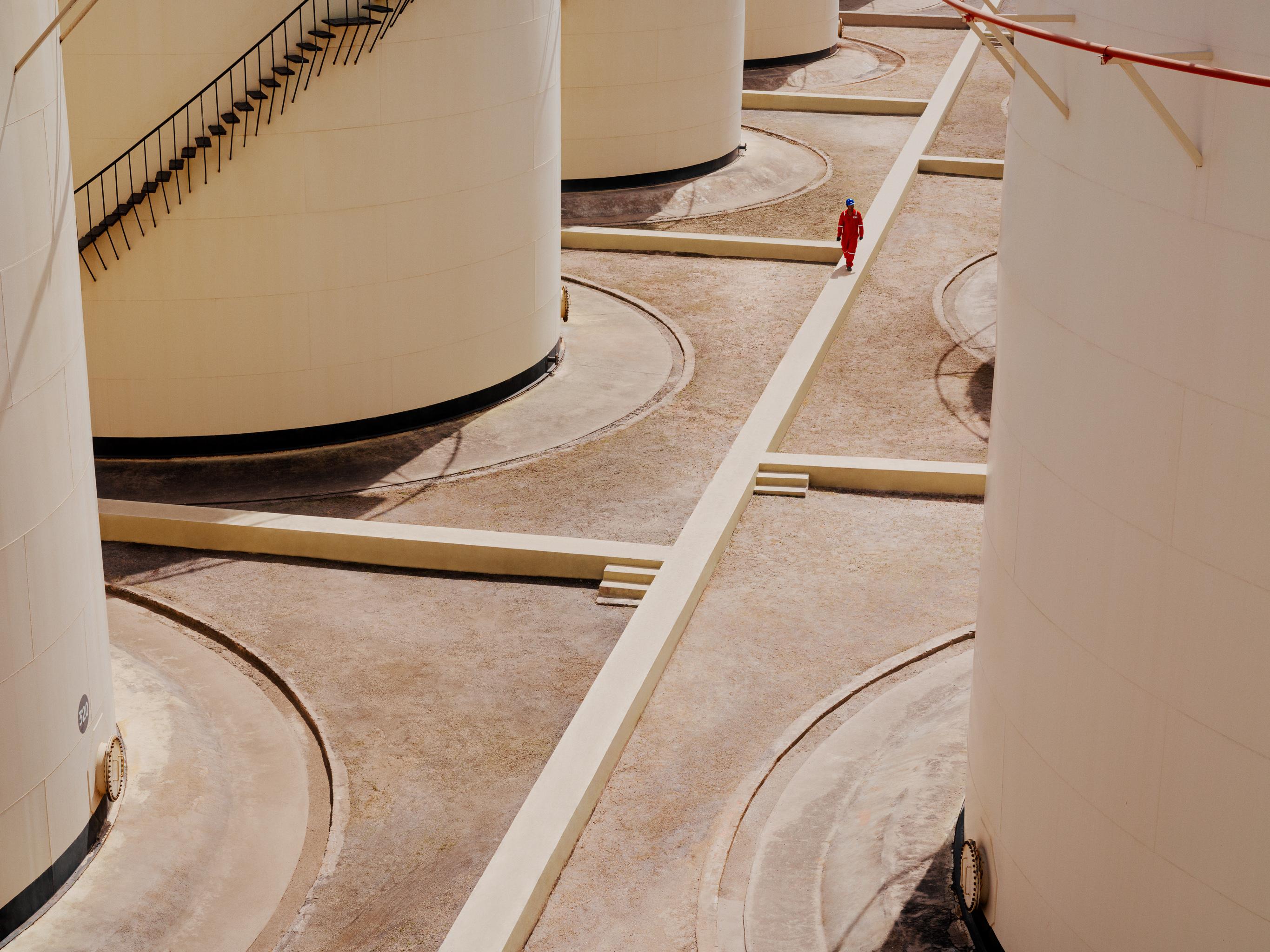 Worker walking between storage tanks at Kandla