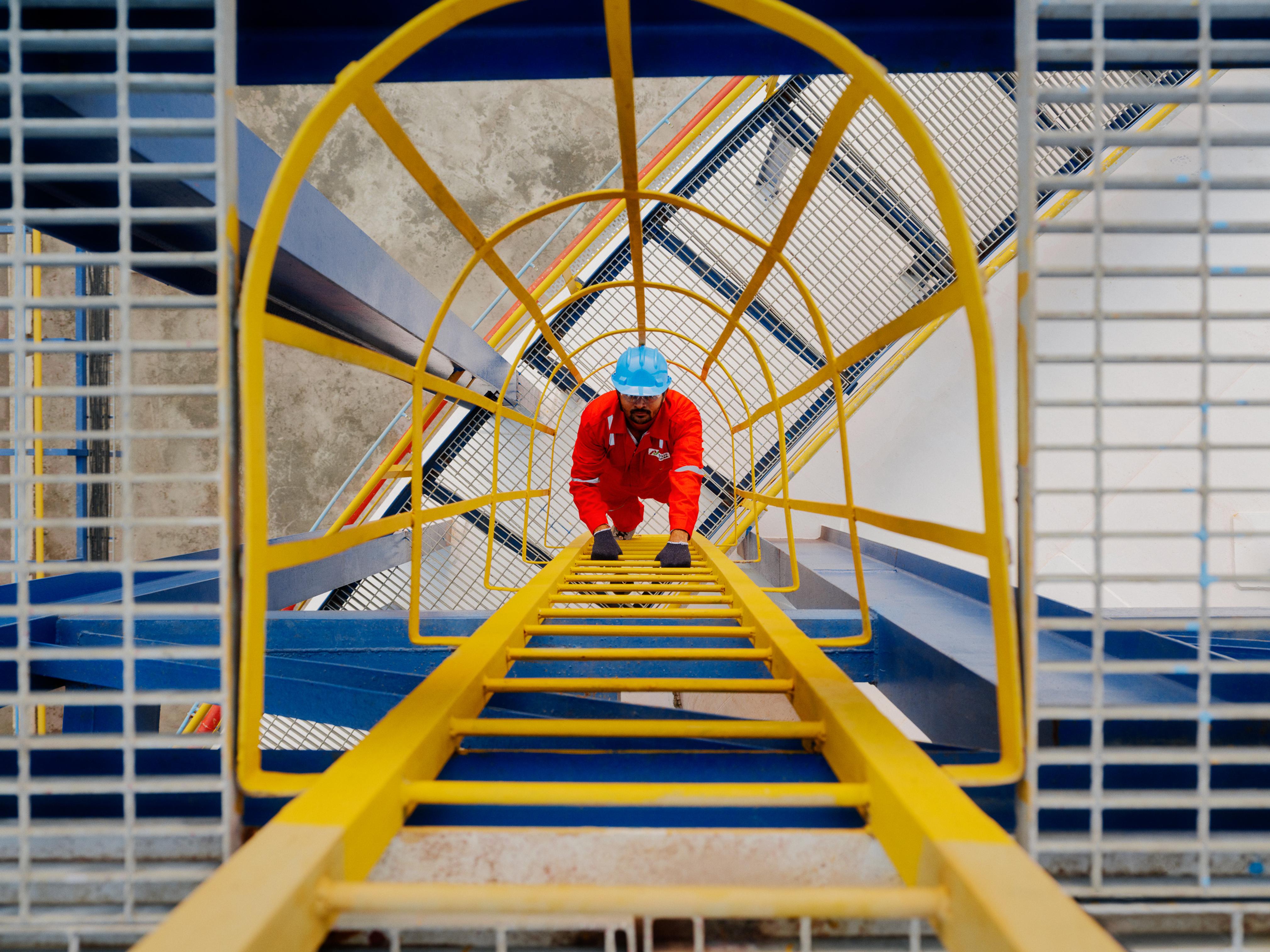 Top down view of an AVTL worker climbing a ladder