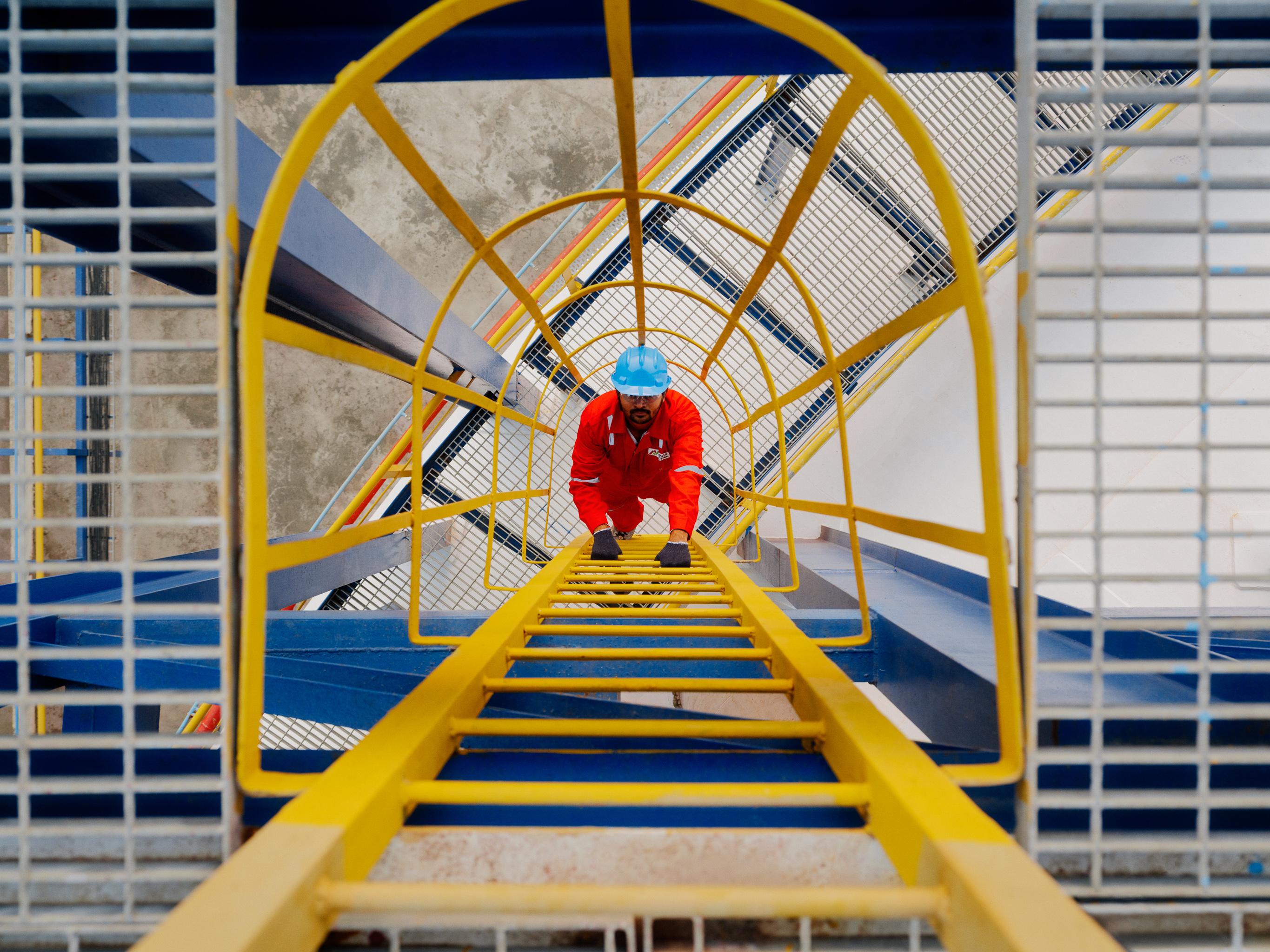 Top down view of an AVTL worker climbing a ladder