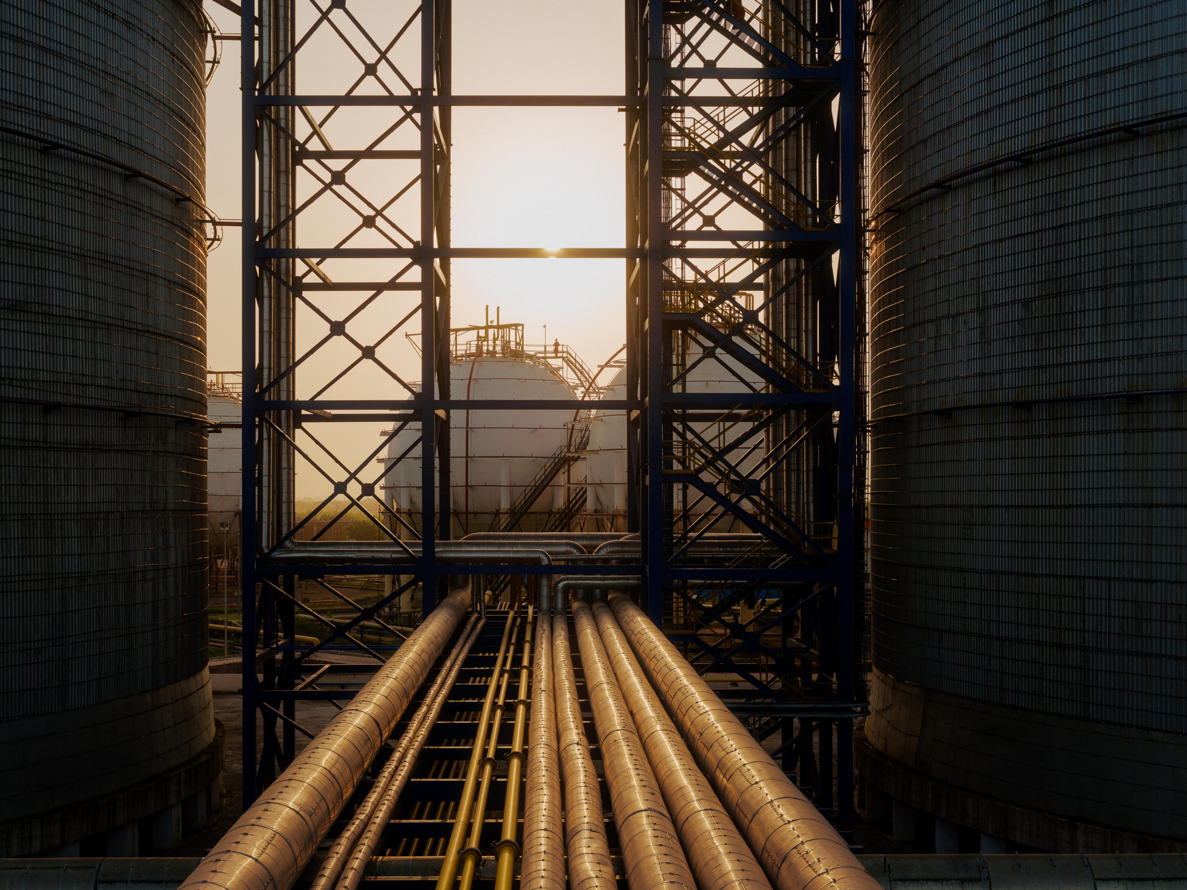 Two spherical tanks are in view as the sun sets.