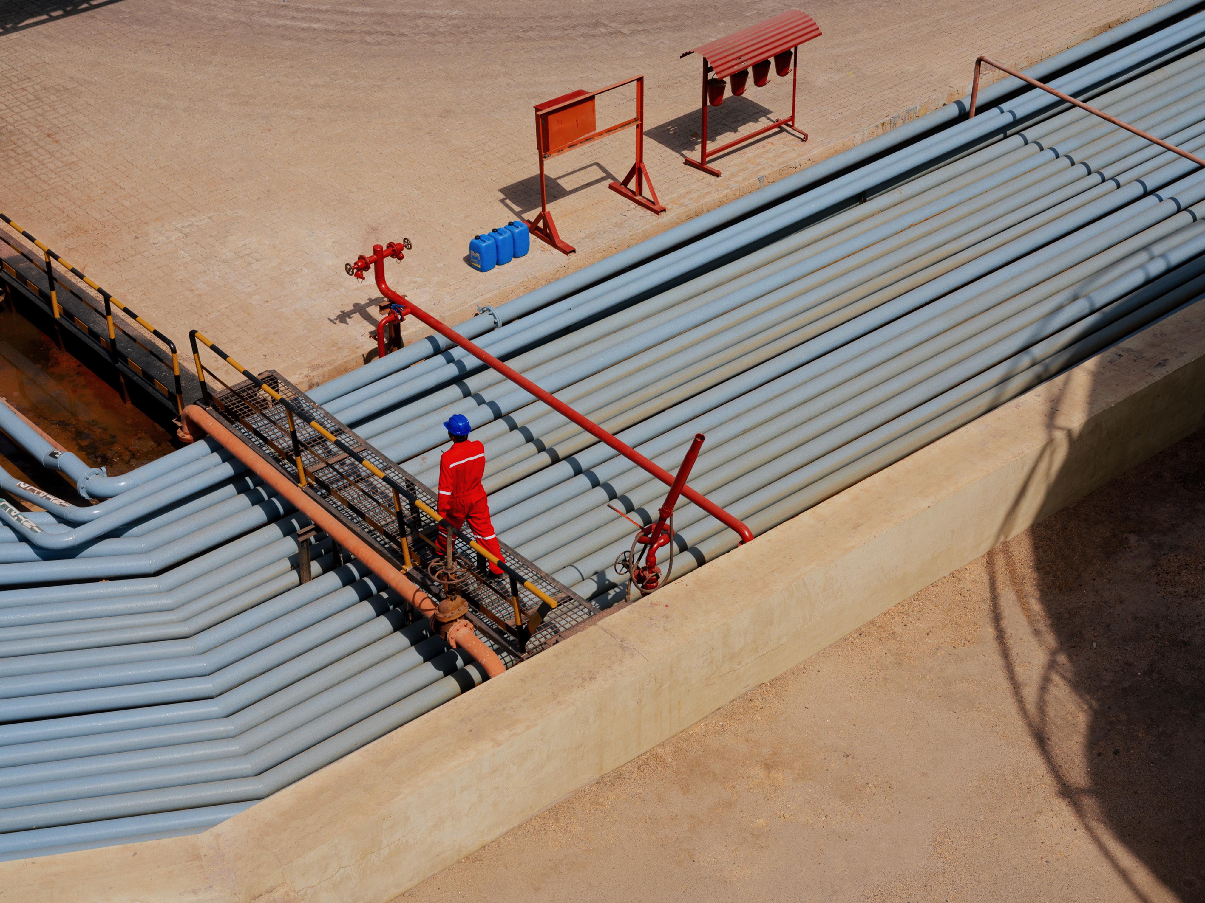 AVTL worker crosses over a series of pipes.