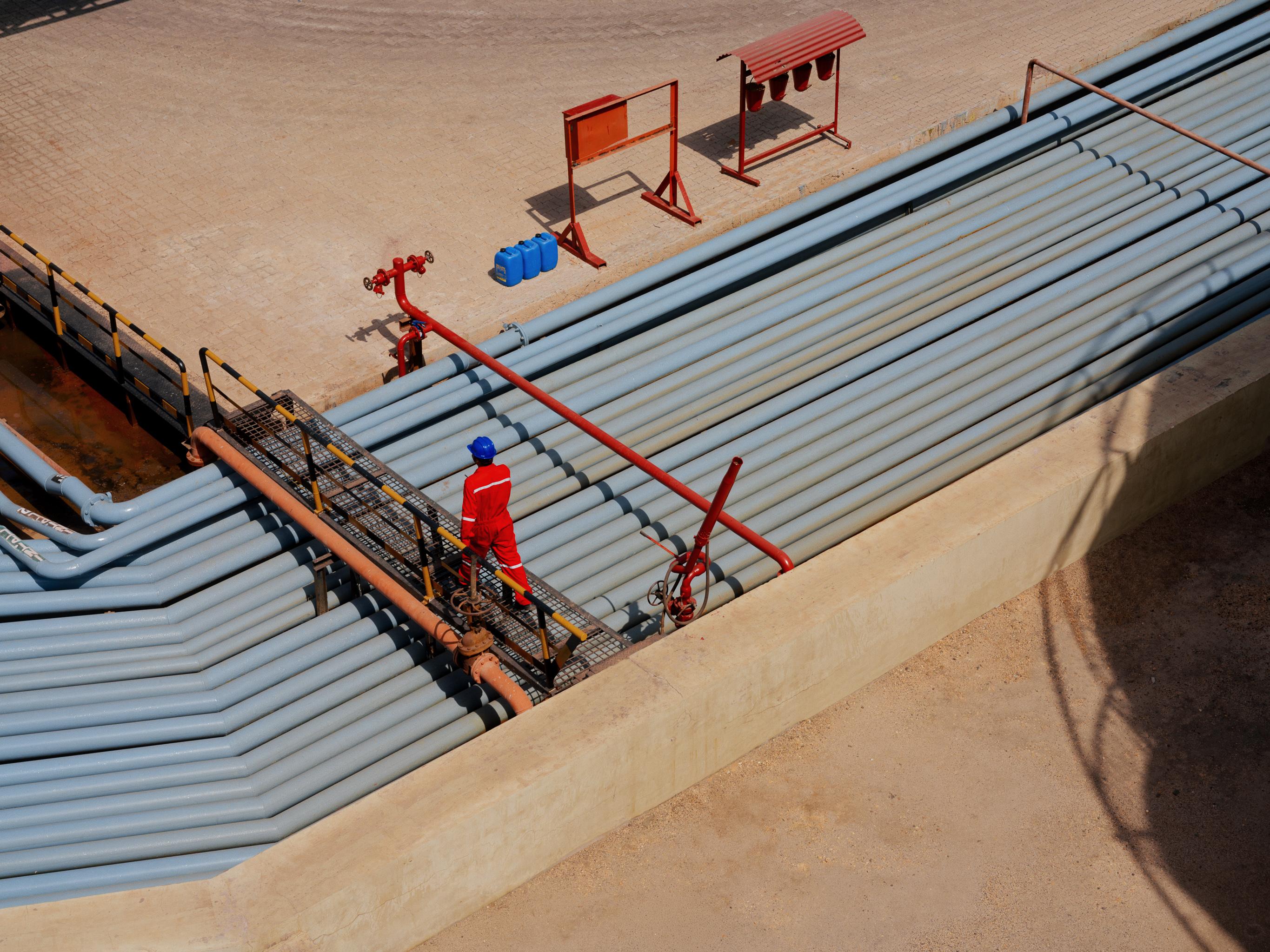 AVTL worker crosses over a series of pipes.
