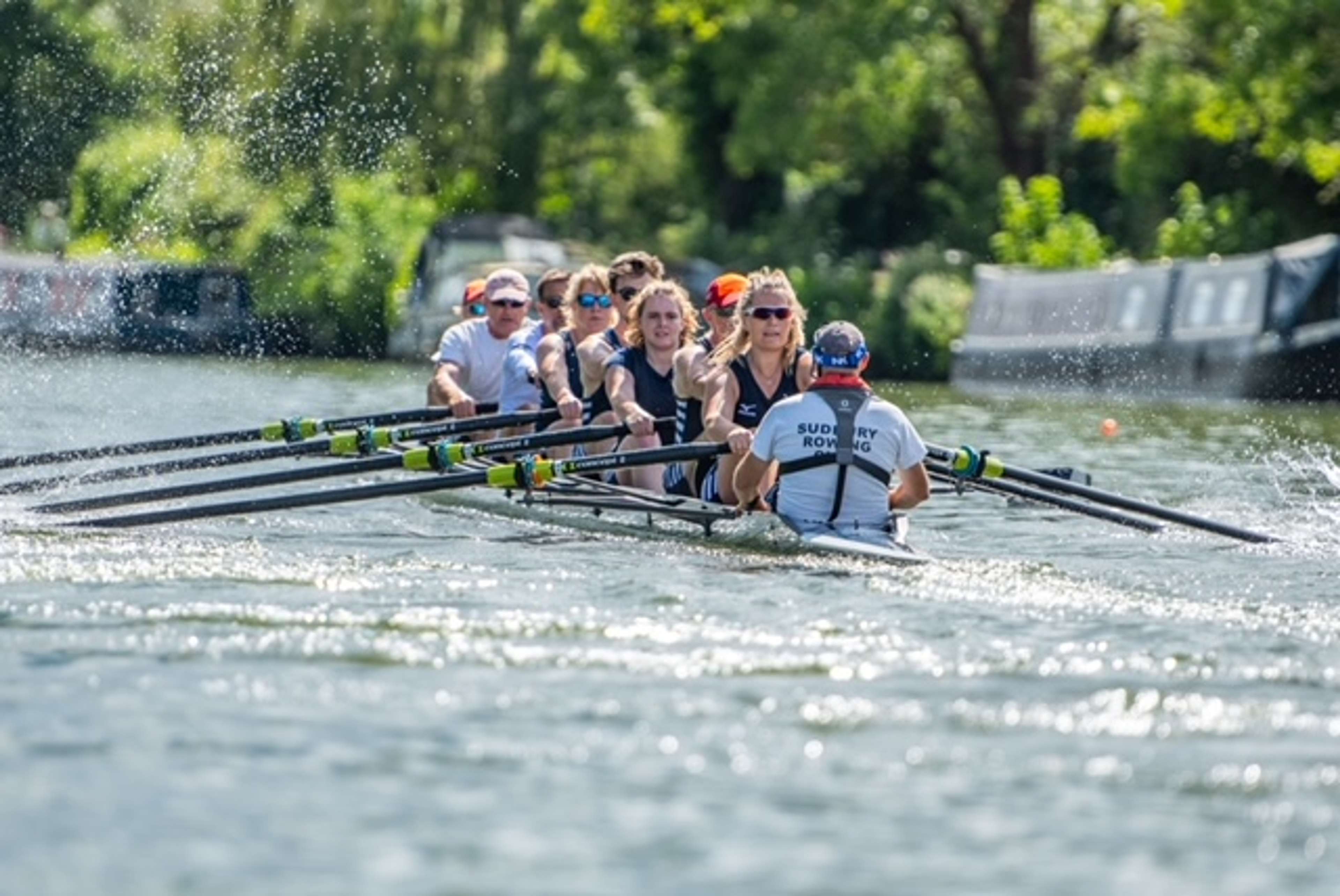 The Sudbury eight thrashes its way down-river, amidst considerable blade-borne spray.