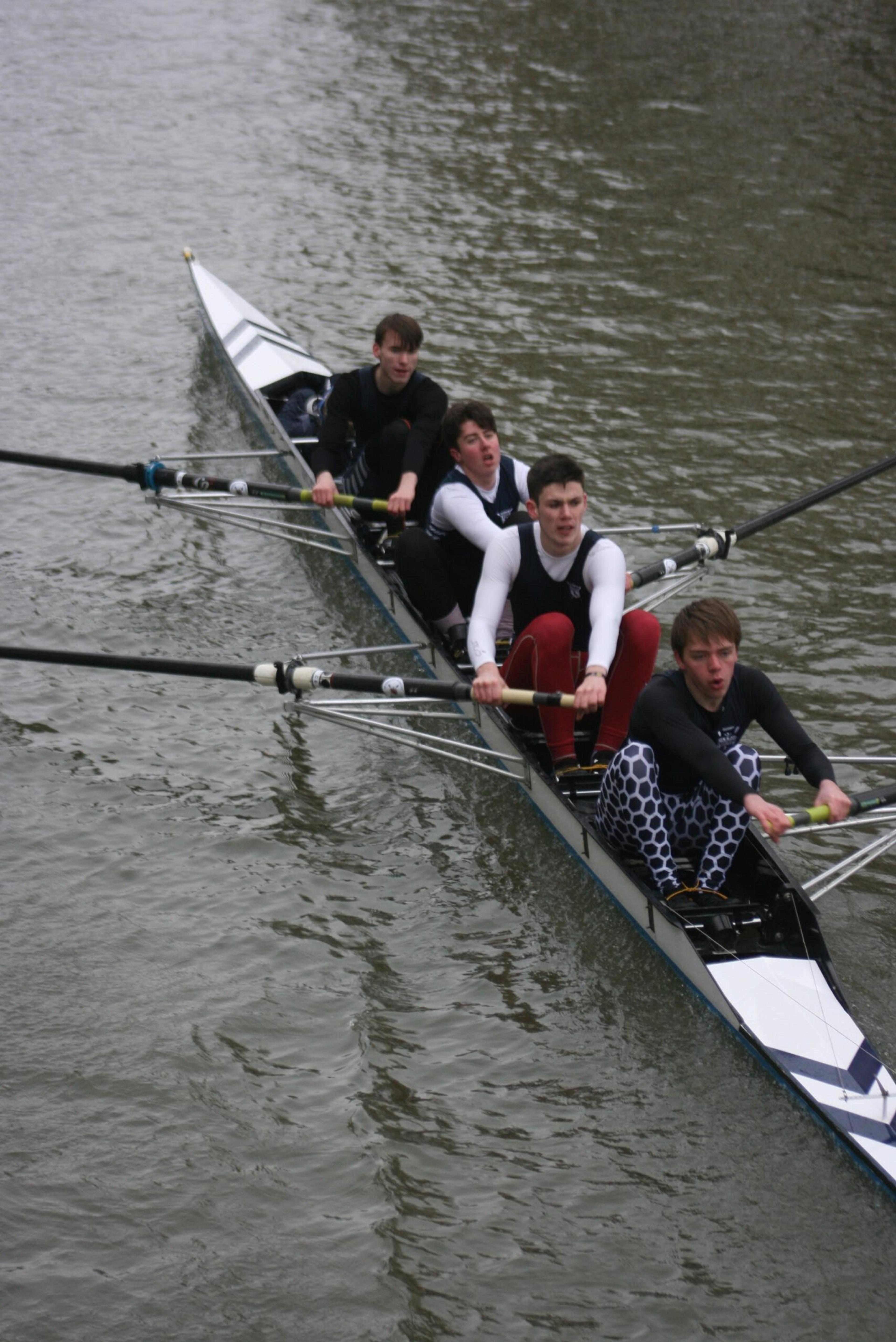 The men’s novice coxed four, looking tired on the smooth green water.