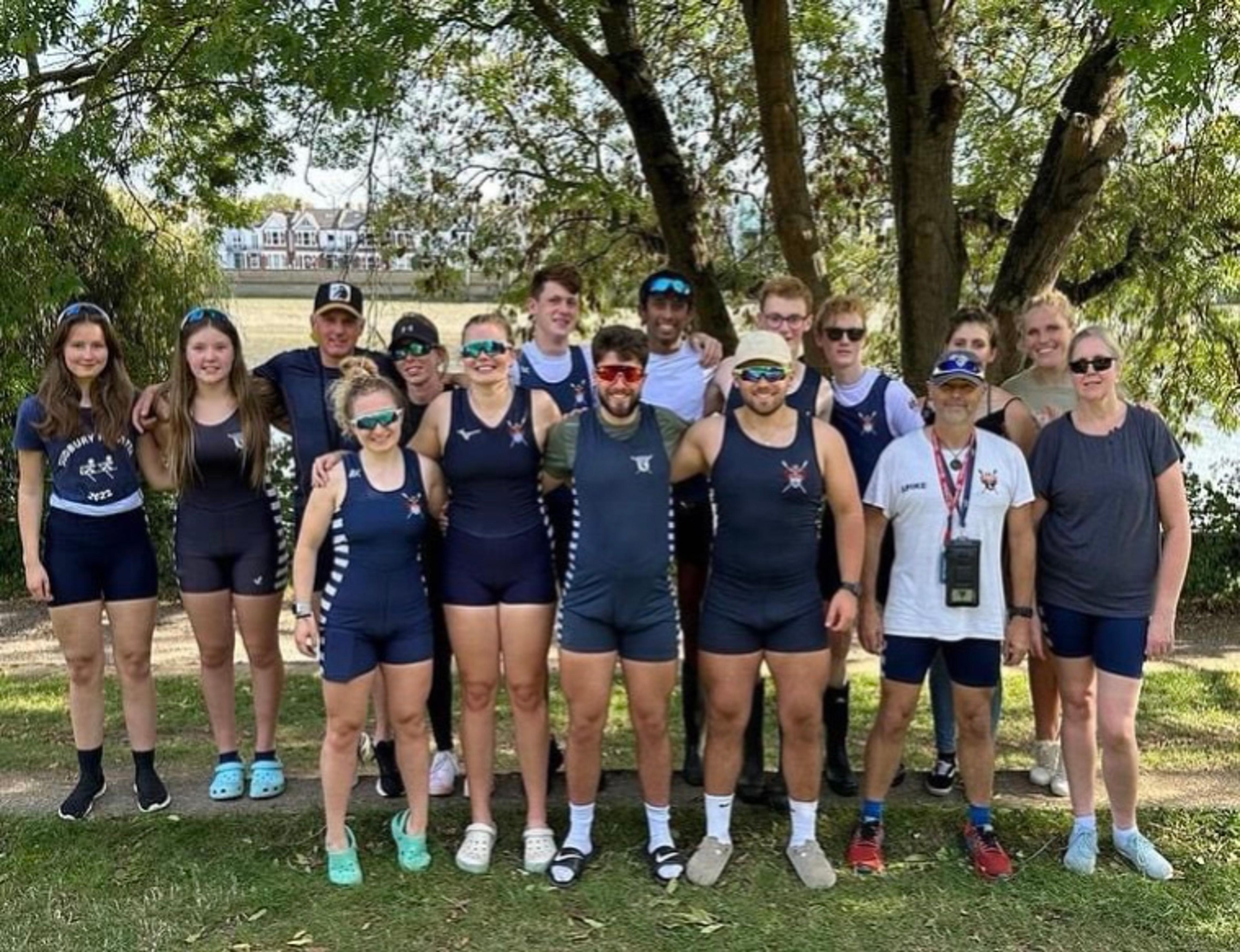 Smiling Sudbury entrants pose beneath a tree in green leaf in a grassy area.
