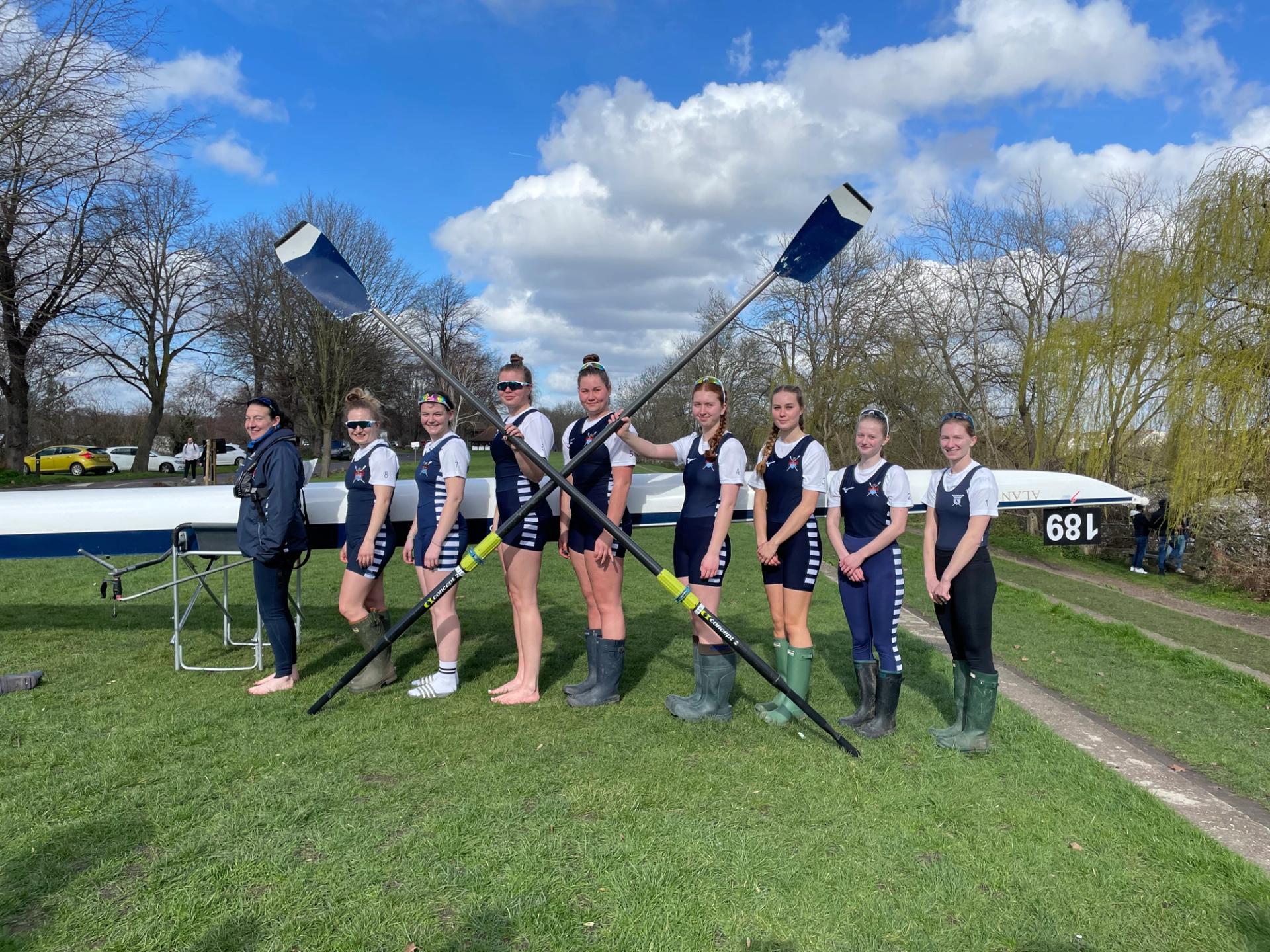 The crew standing on the bank with a crossed pair of blades.