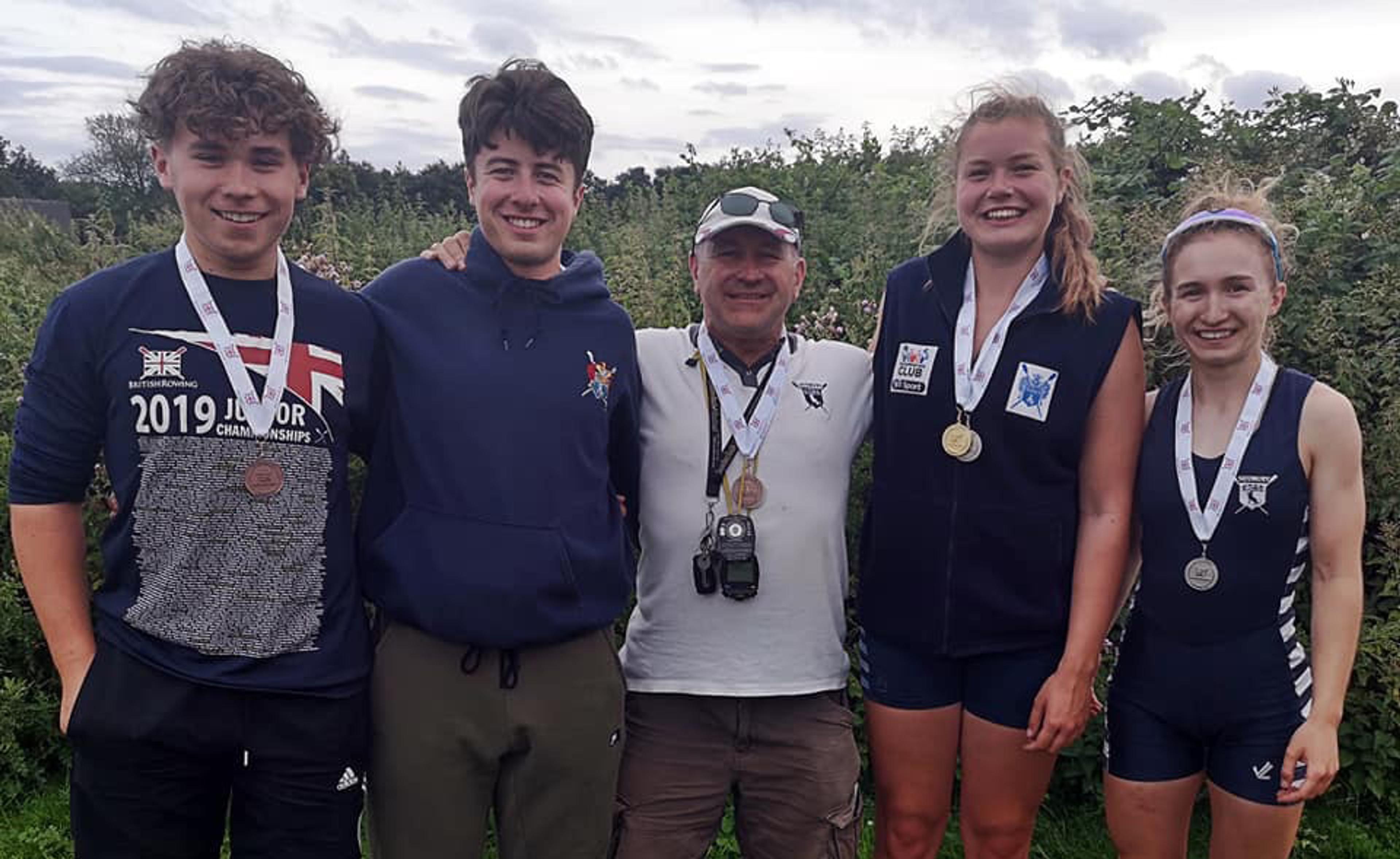 Sudbury’s four, very-happy-looking competing juniors pose for a photo with their coach.