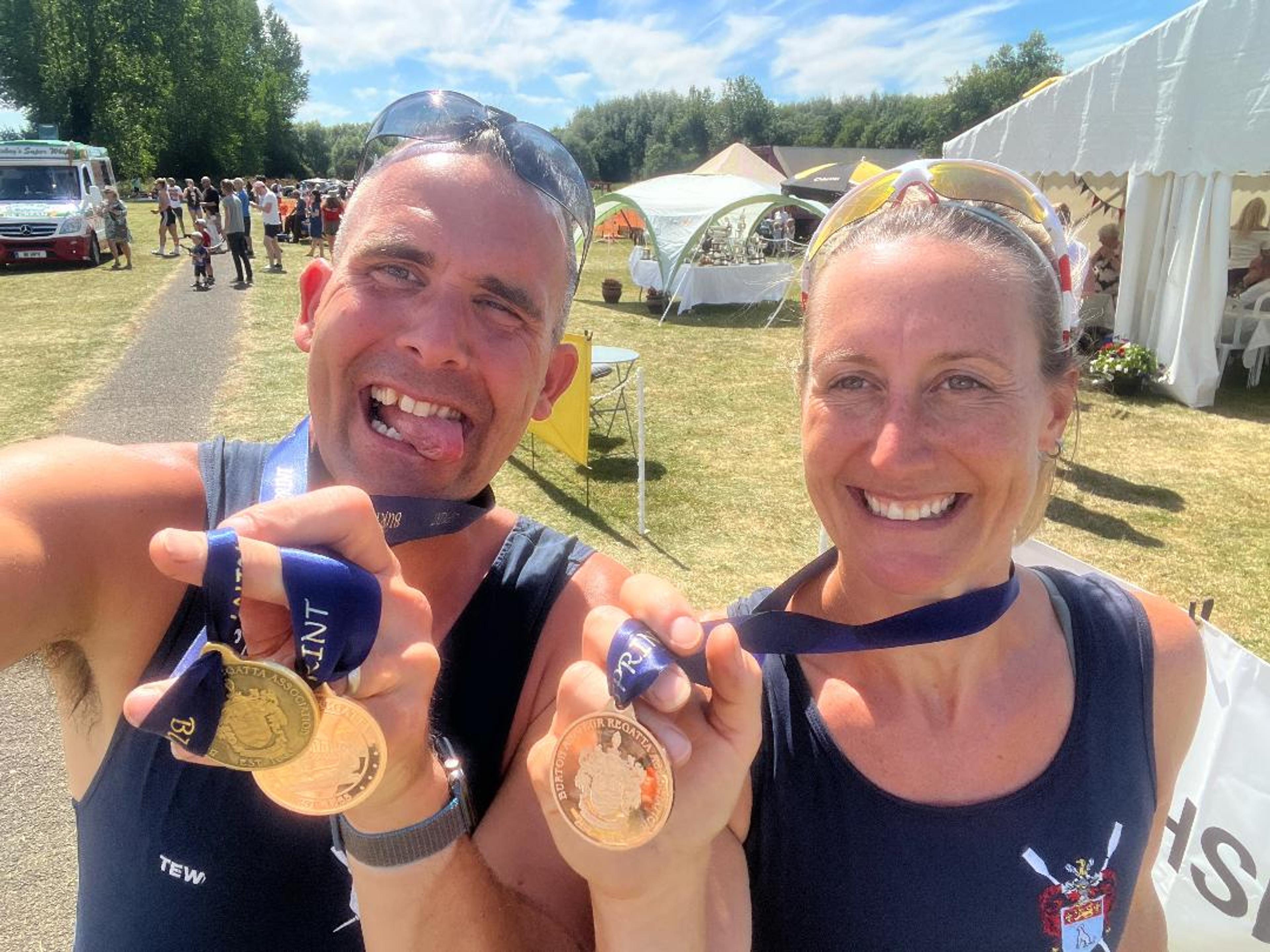 Two rowers show off their medals at a very warm regatta in the East Midlands.
