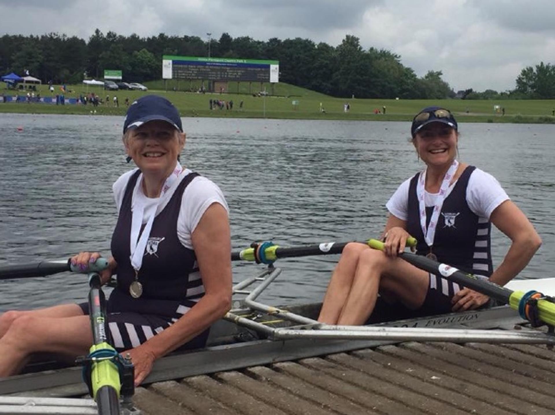 Our smiling silver medalists, wearing medals but still in their seats (blades in hand) at the landing stage at the Massive Expanse of Water in Nottingham.