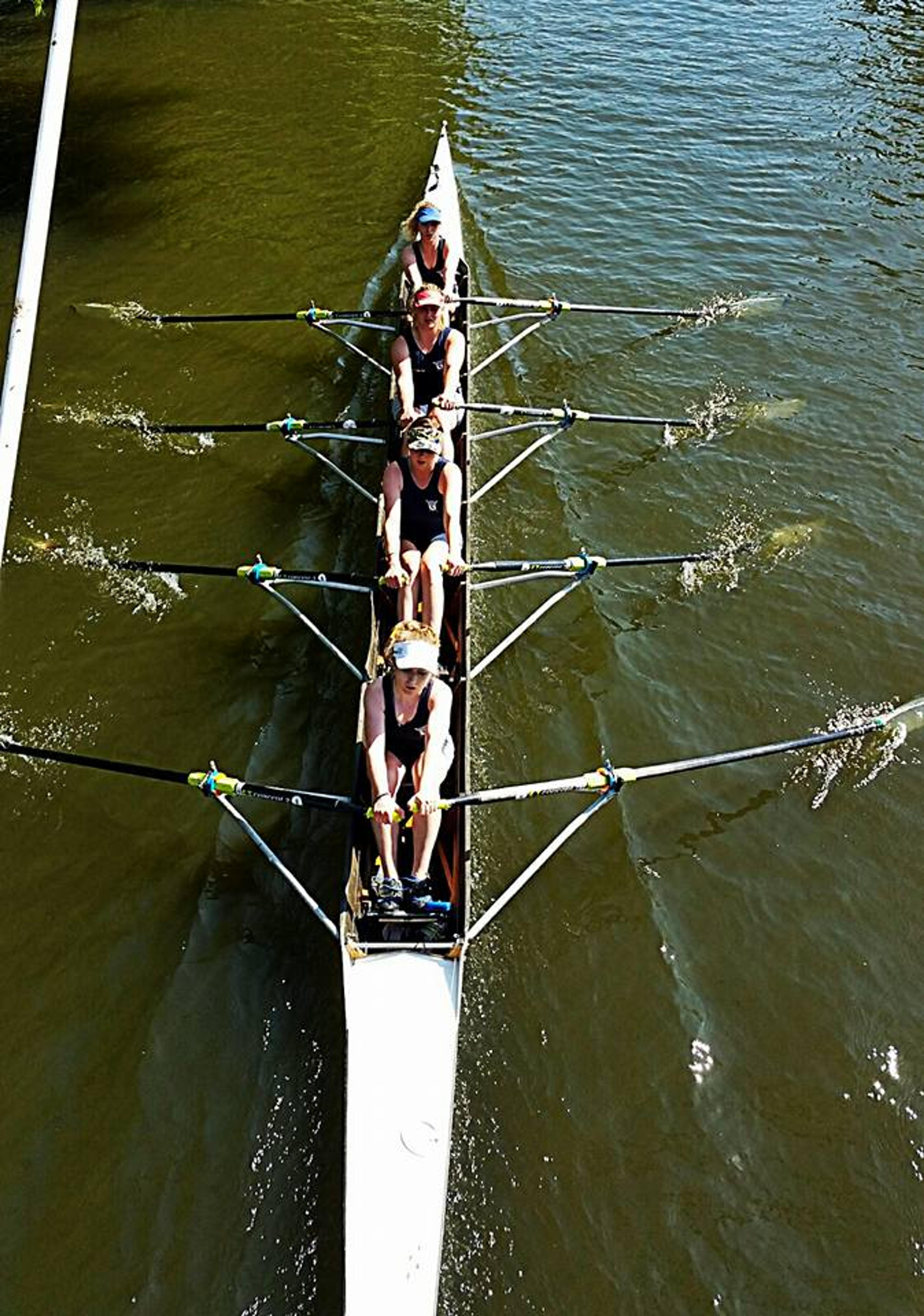 The tidy-looking ladies’ J18 quad passes under a bridge, skimming Bedford’s spectacularly khaki water.