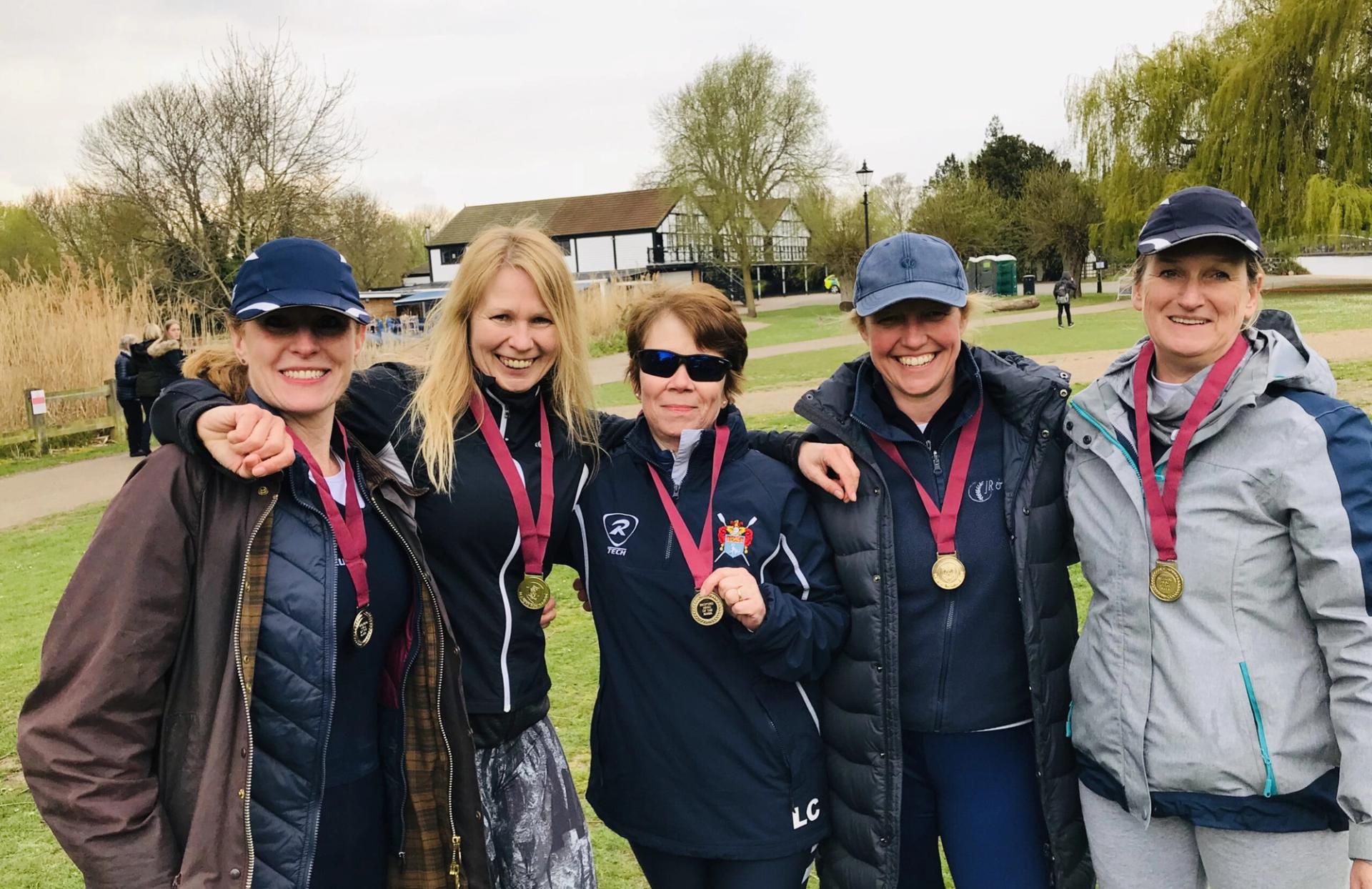 The four victorious ladies of the women’s masters D coxed quad smiling with their medals. 