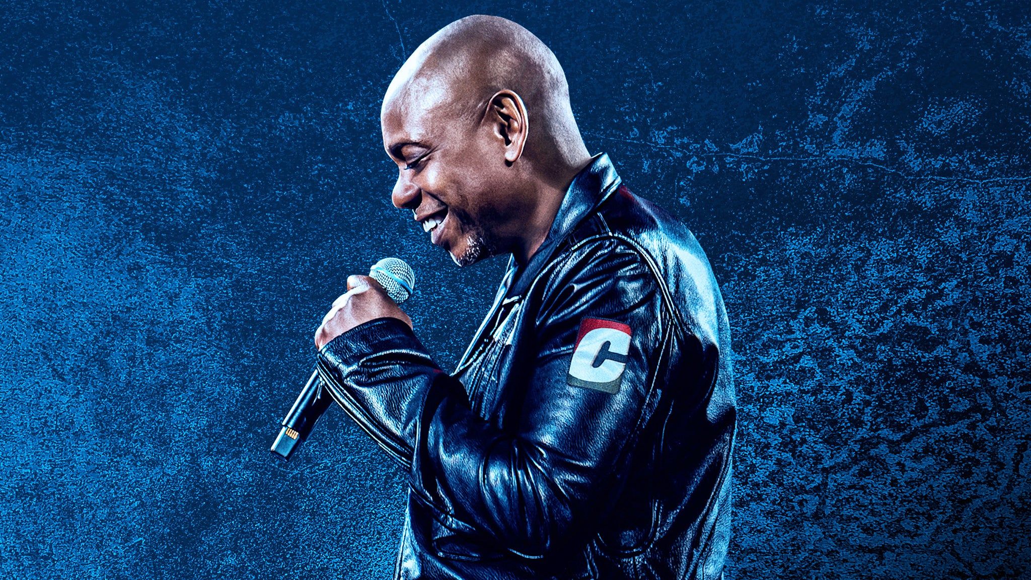 Dave Chappelle performing live on stage during his 2026 summer arena tour