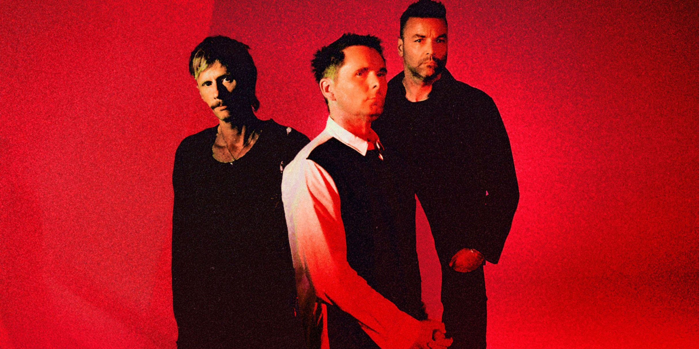 Muse performing live on stage during a concert