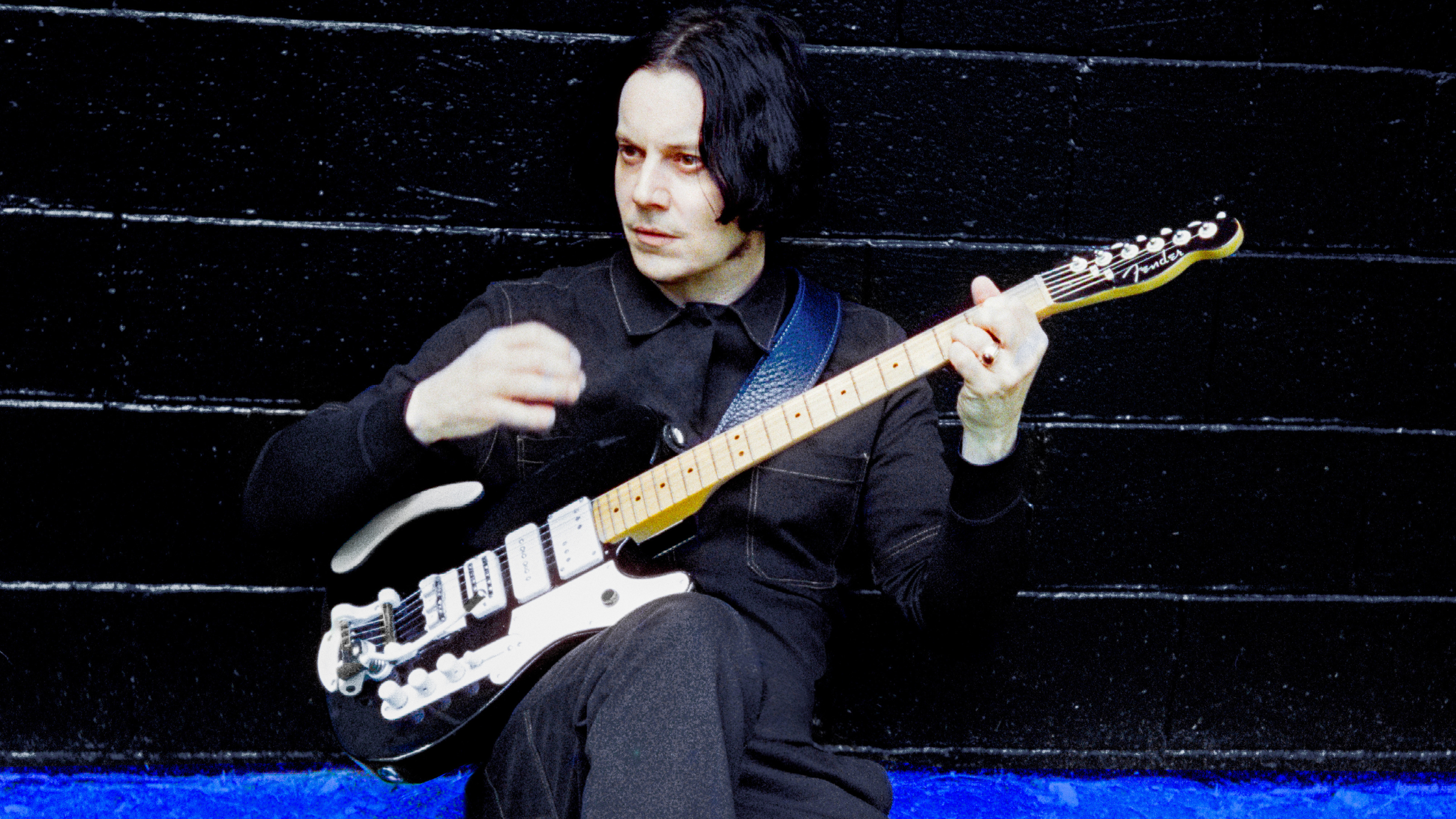Jack White performing live on stage at a music festival