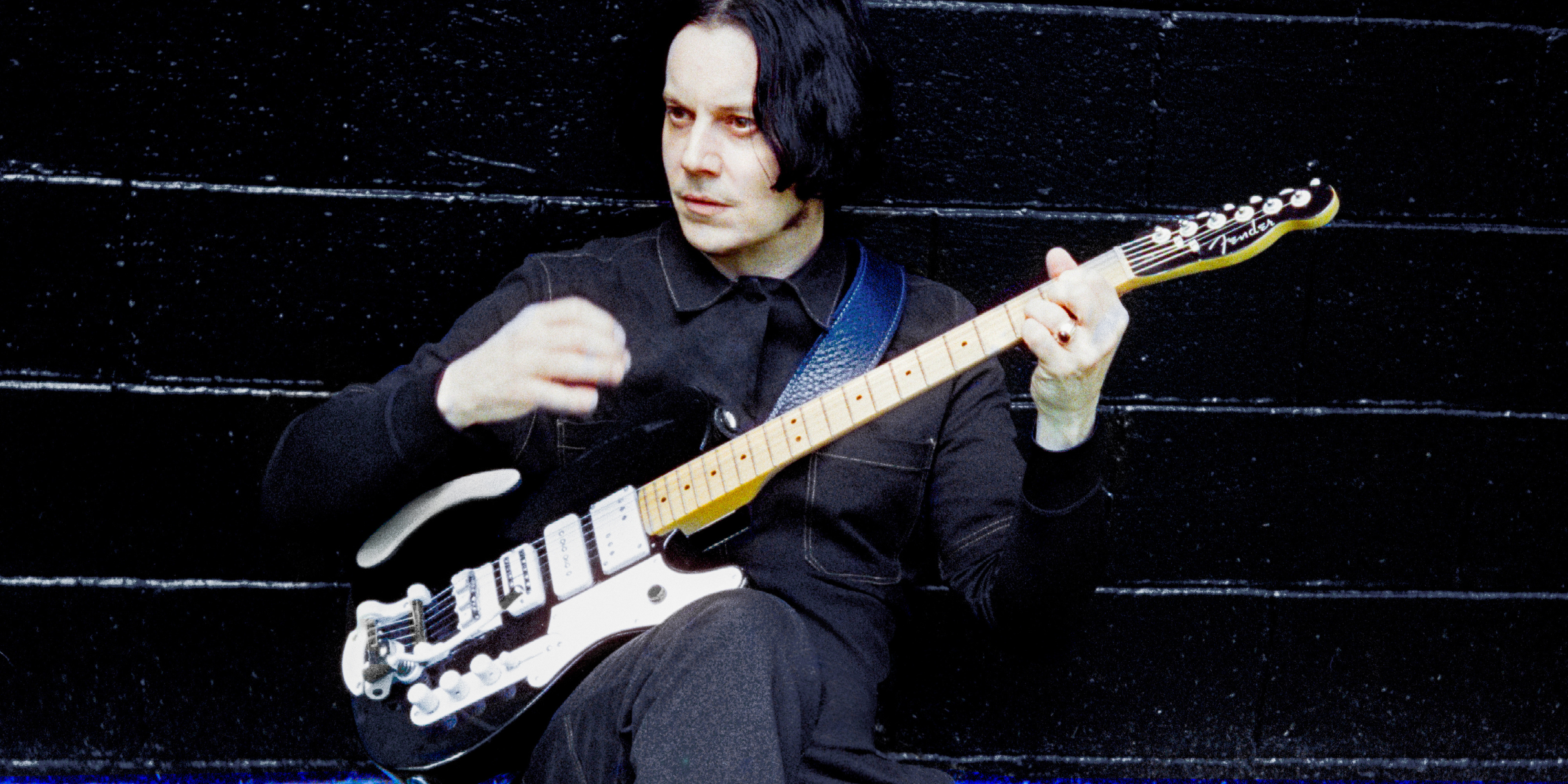 Jack White performing live on stage at a music festival