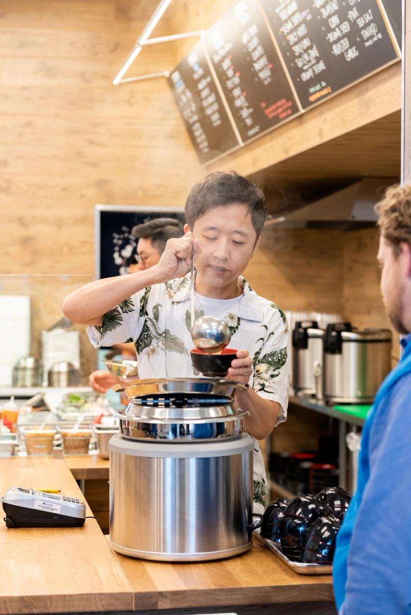 Joy Poke owner Justin Hwang serves steaming miso soup to a customer