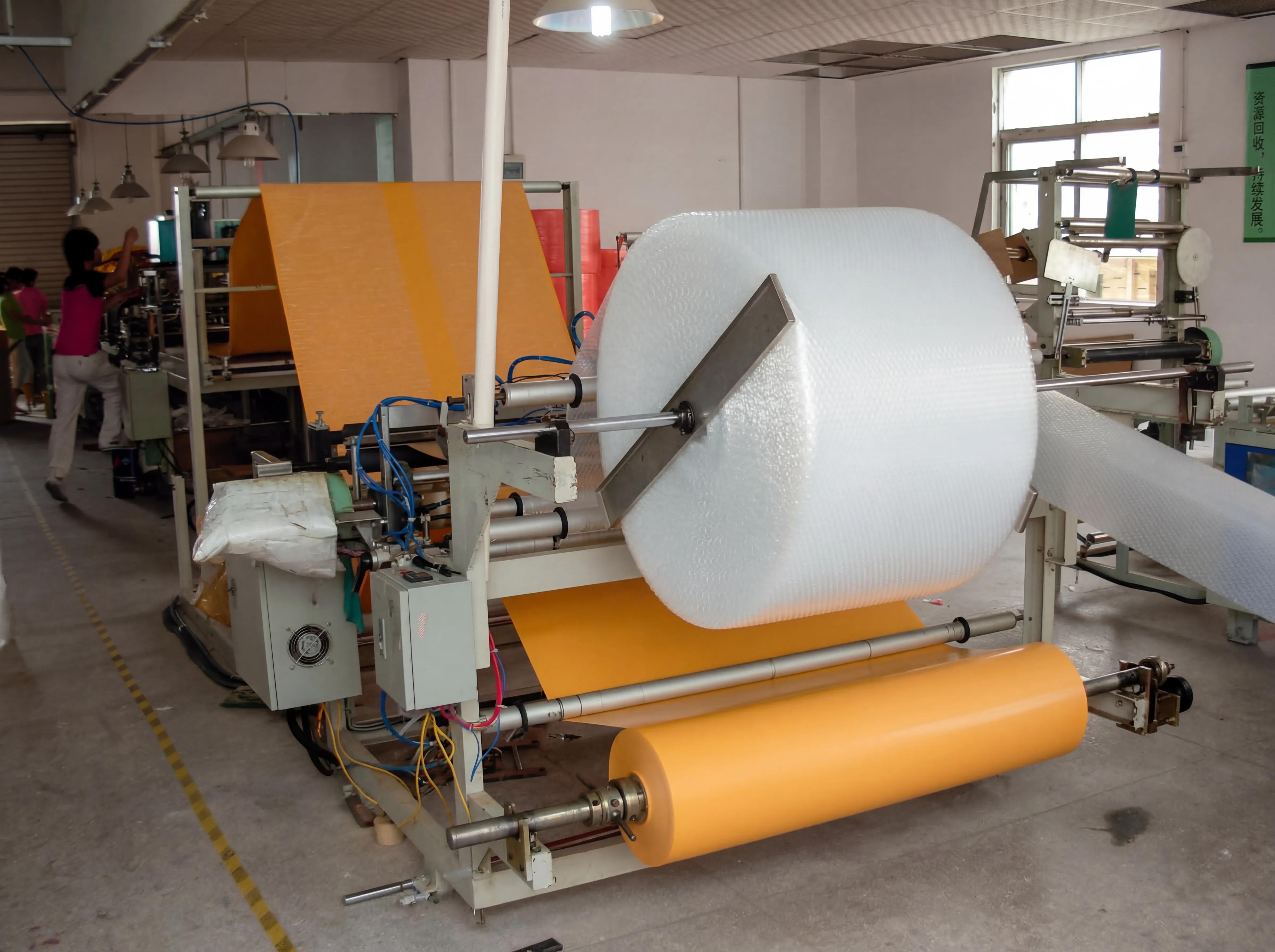 Automated production line laminating premium kraft paper with protective bubble wrap at Shinekin Packing factory for bulk mailer manufacturing.