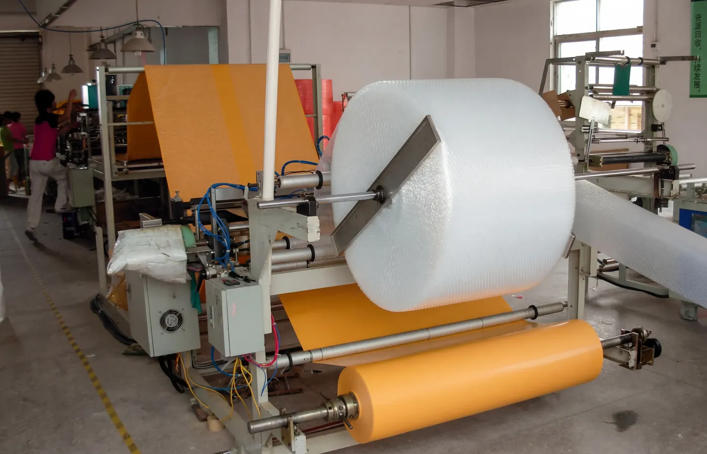 Automated production line laminating premium kraft paper with protective bubble wrap at Shinekin Packing factory for bulk mailer manufacturing.