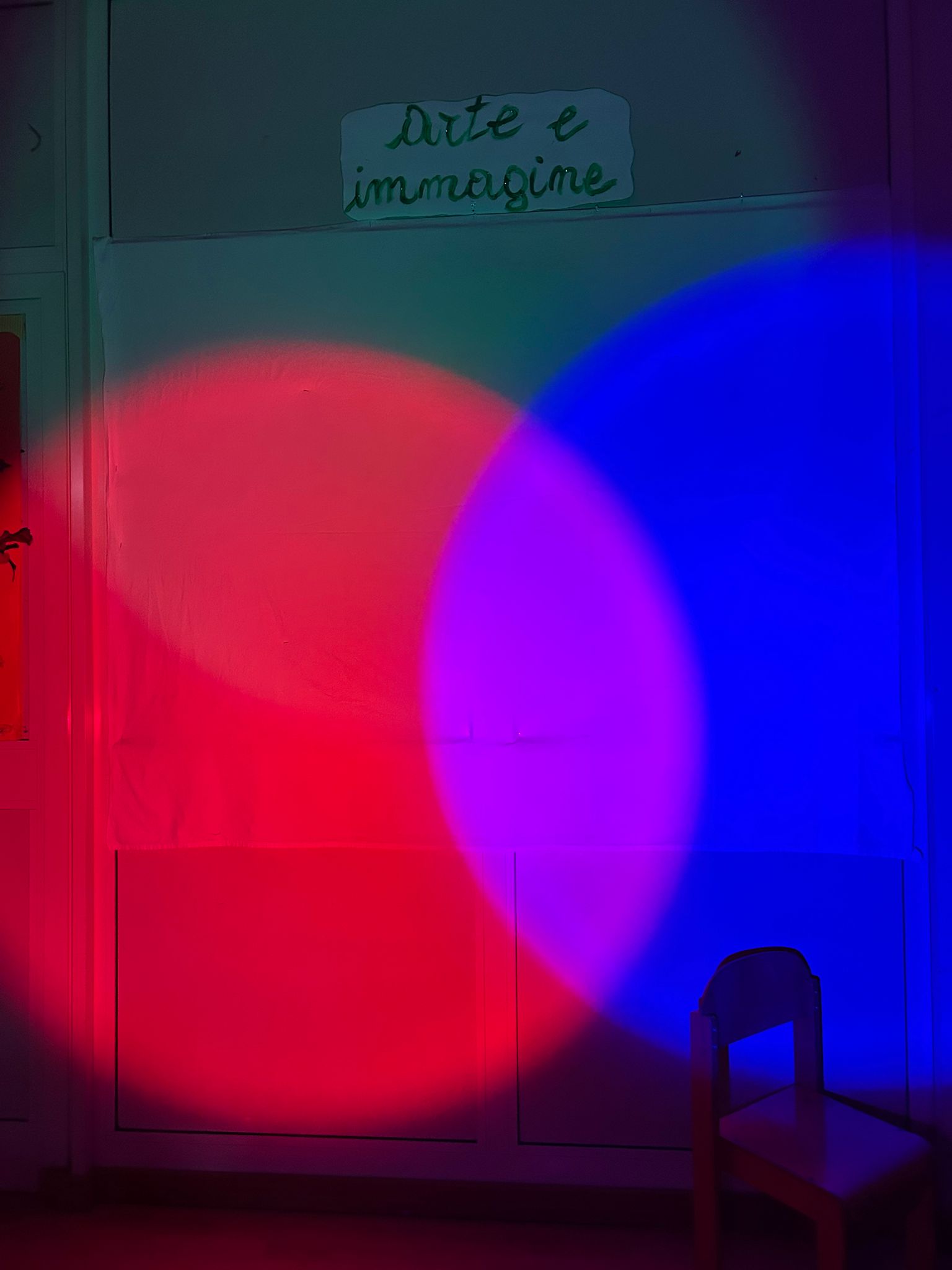 Una luce rossa e una blu che si sovrappongono sul muro