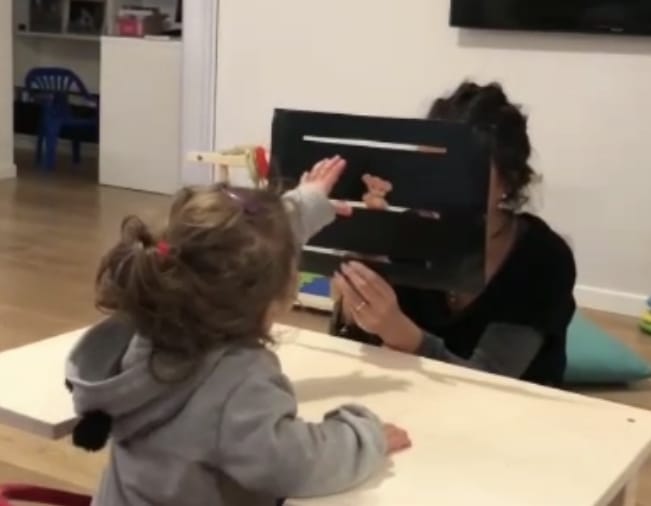 Una bambina gioca a un tavolino con un’educatrice