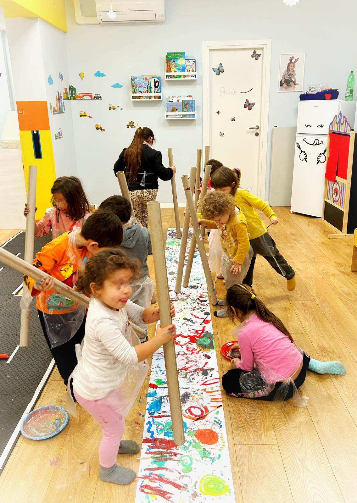 Bambini che dipingono su un lungo rotolo di carta
