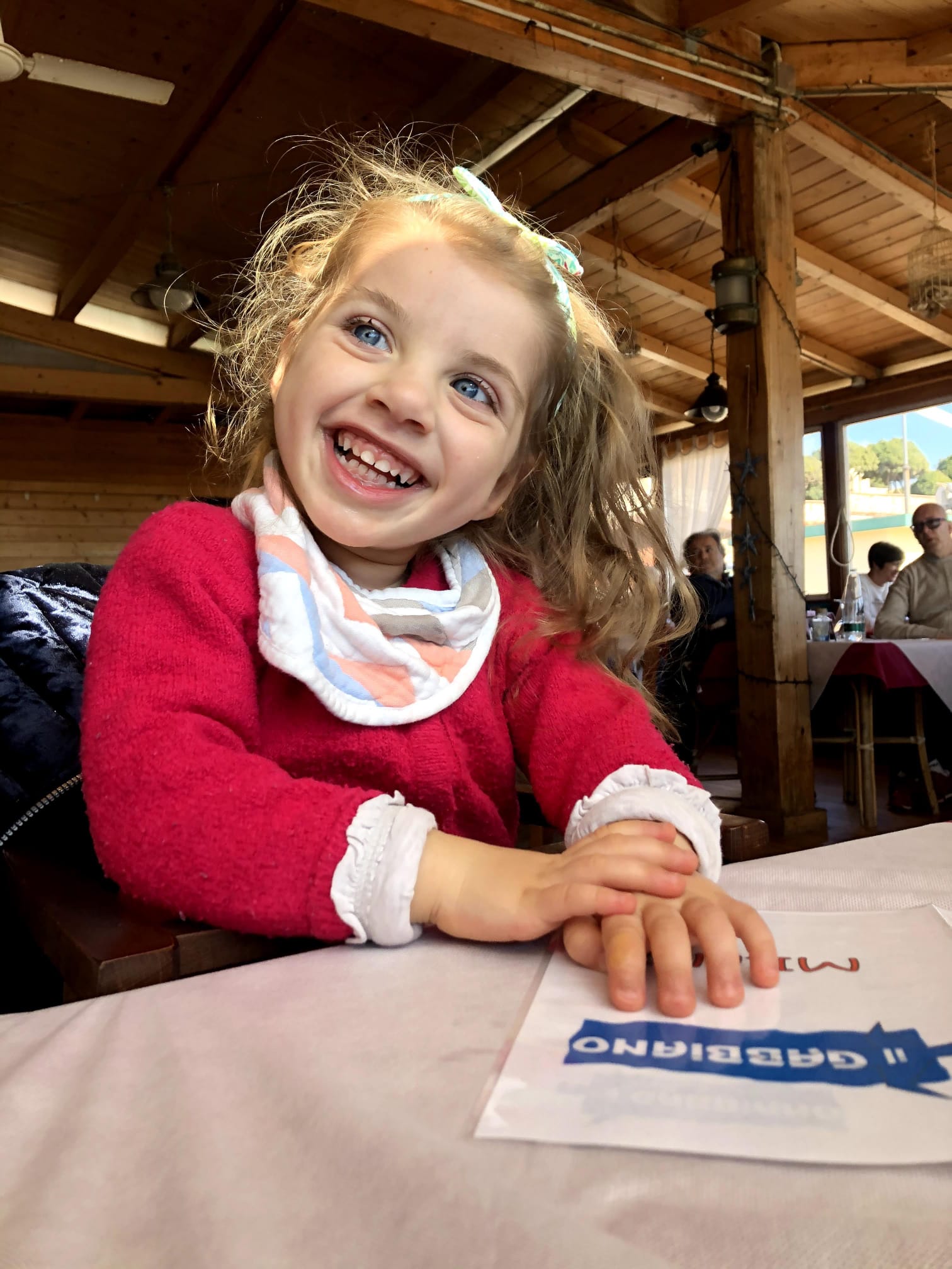 Una bambina sorride seduta a tavola