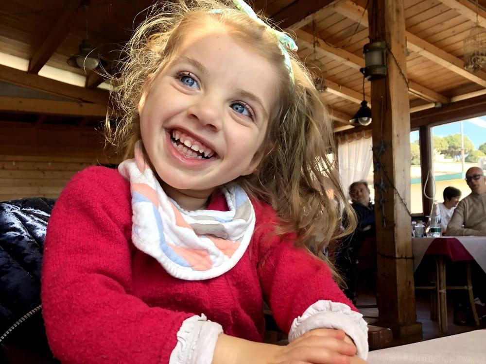 Una bambina sorride seduta a tavola