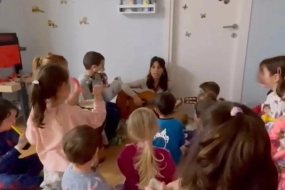 Bambini seduti per terra con un’animatrice