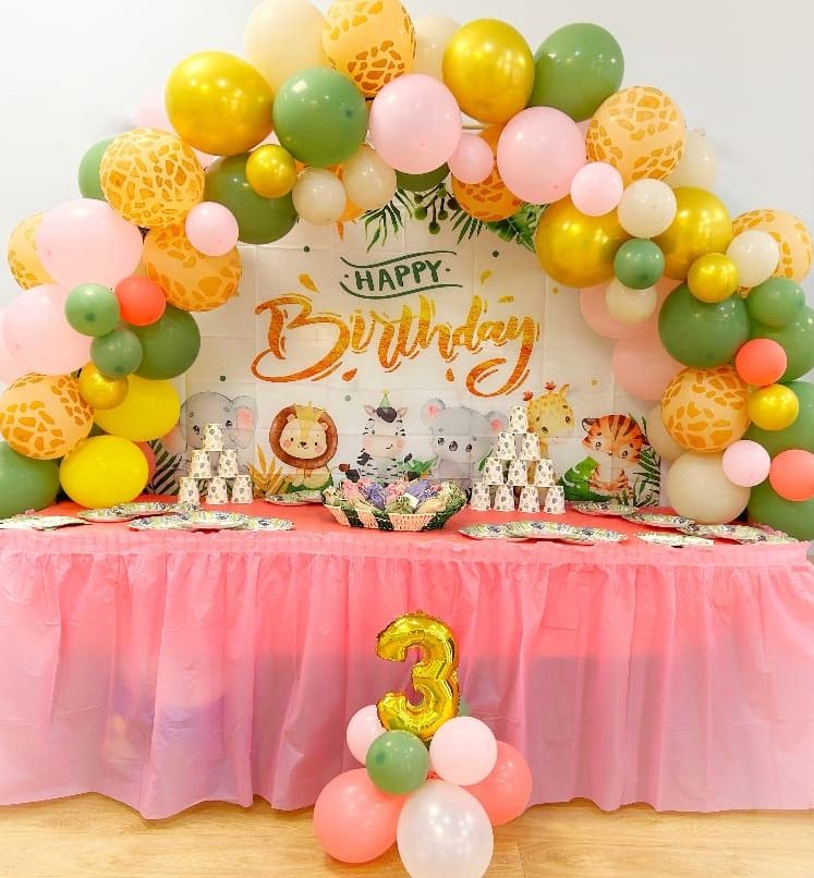 Allestimento a tema animali della giungla: arco di palloncini, sfondo e tavolo con la gonna rosa