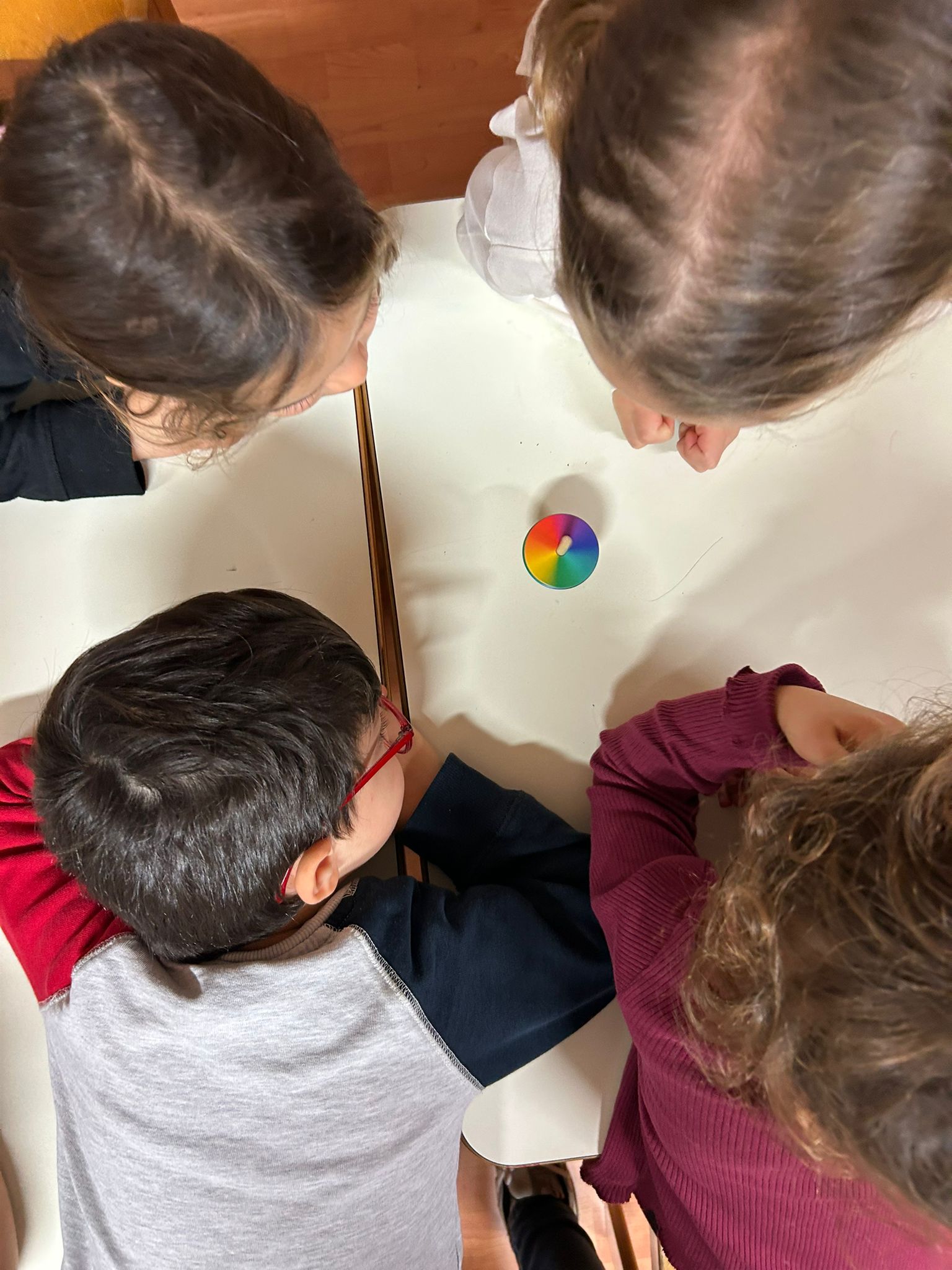 Bambini intorno a un tavolo con il disco dei colori