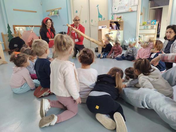 Bambini del nido seduti in cerchio durante il percorso sonoro