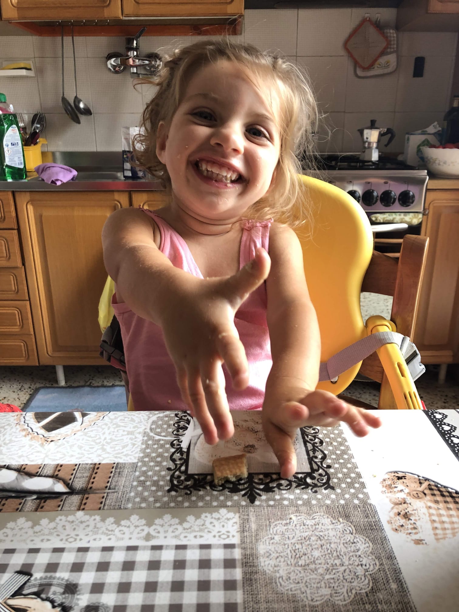 Una bambina in cucina con le mani in pasta