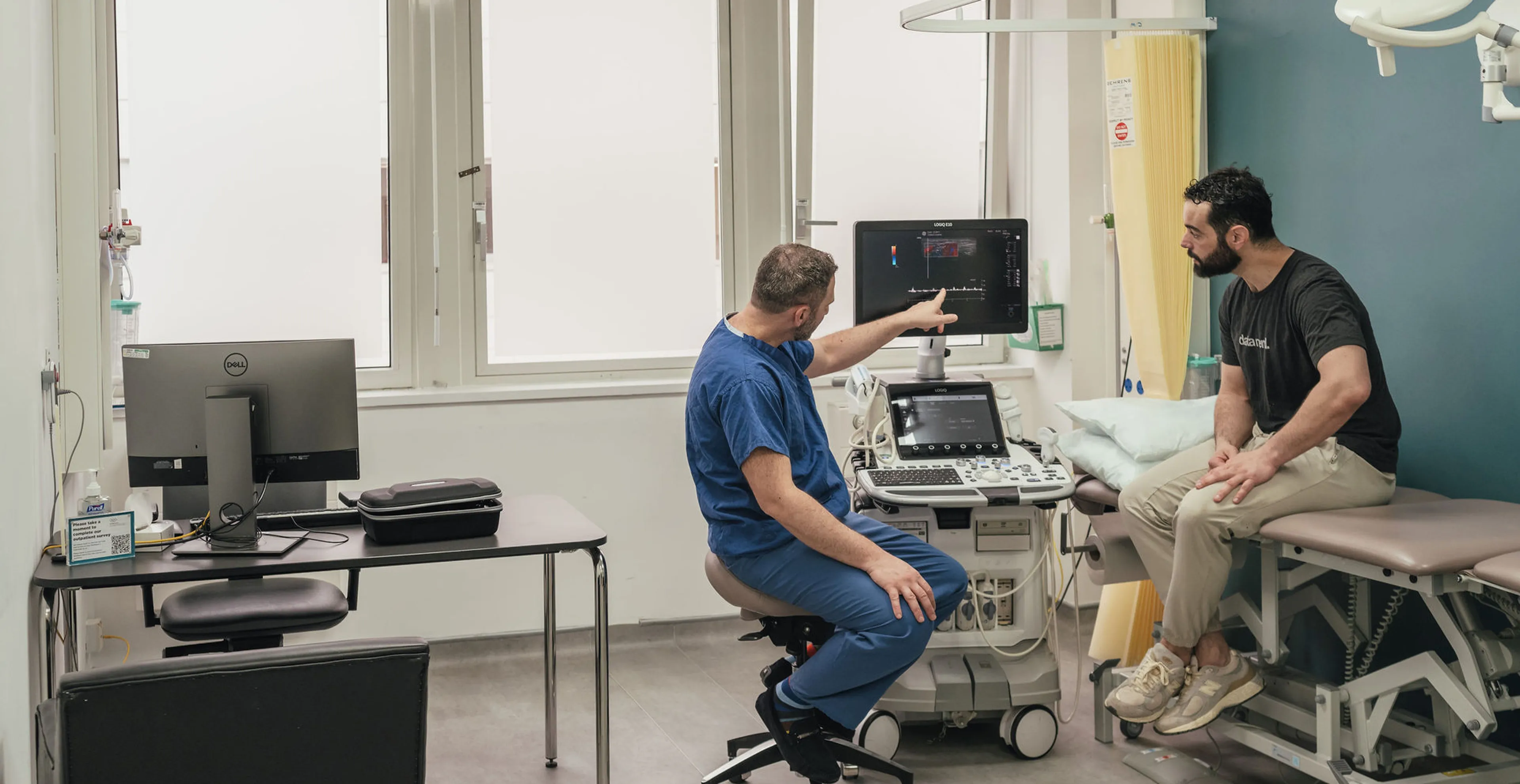 Consultant urologist explaining penile Doppler ultrasound results to a patient during an outpatient andrology assessment in London.